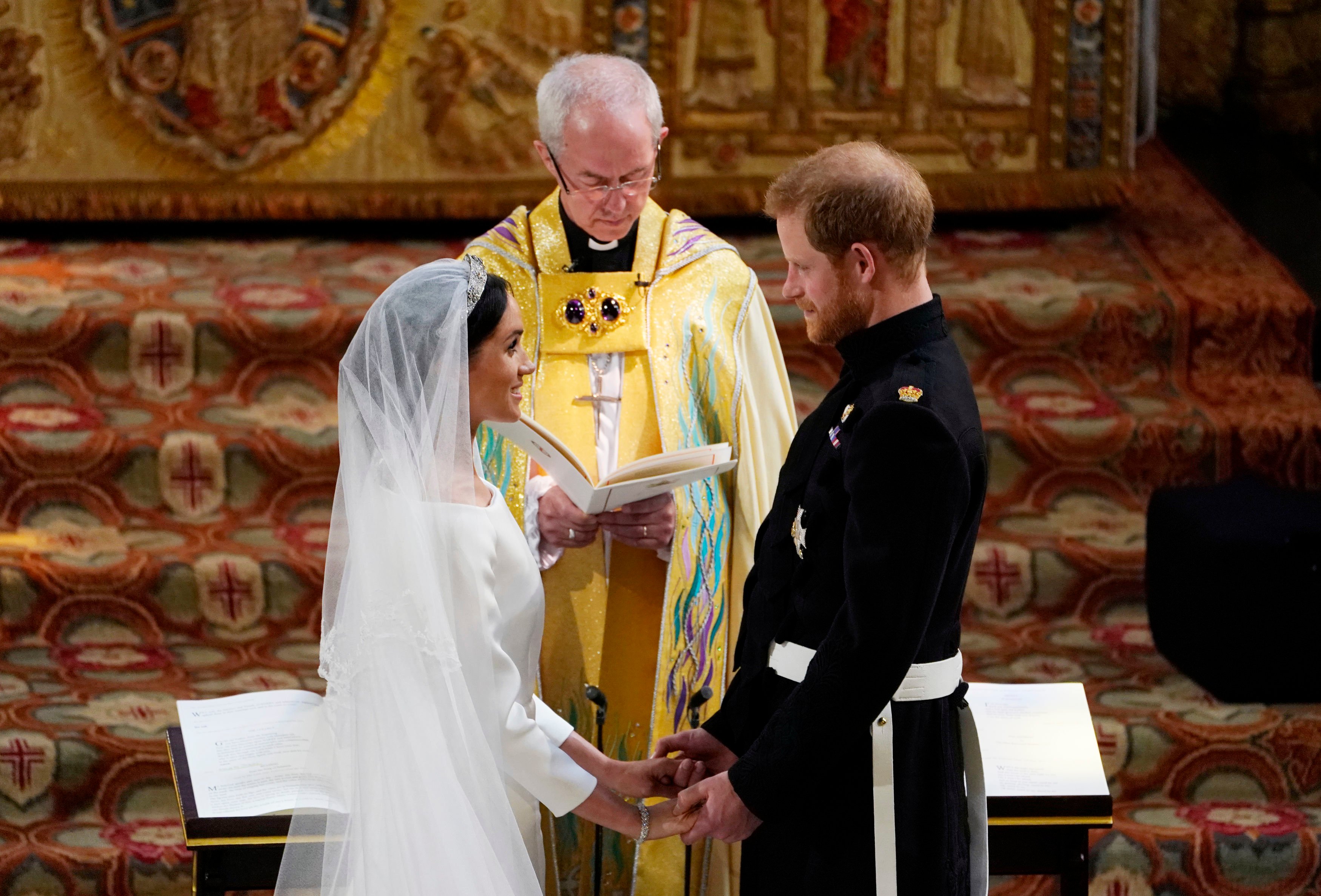 Prince Harry and Meghan Markle stand facing each other in front of Archbishop of Canterbury Justin Welby during wedding ceremony