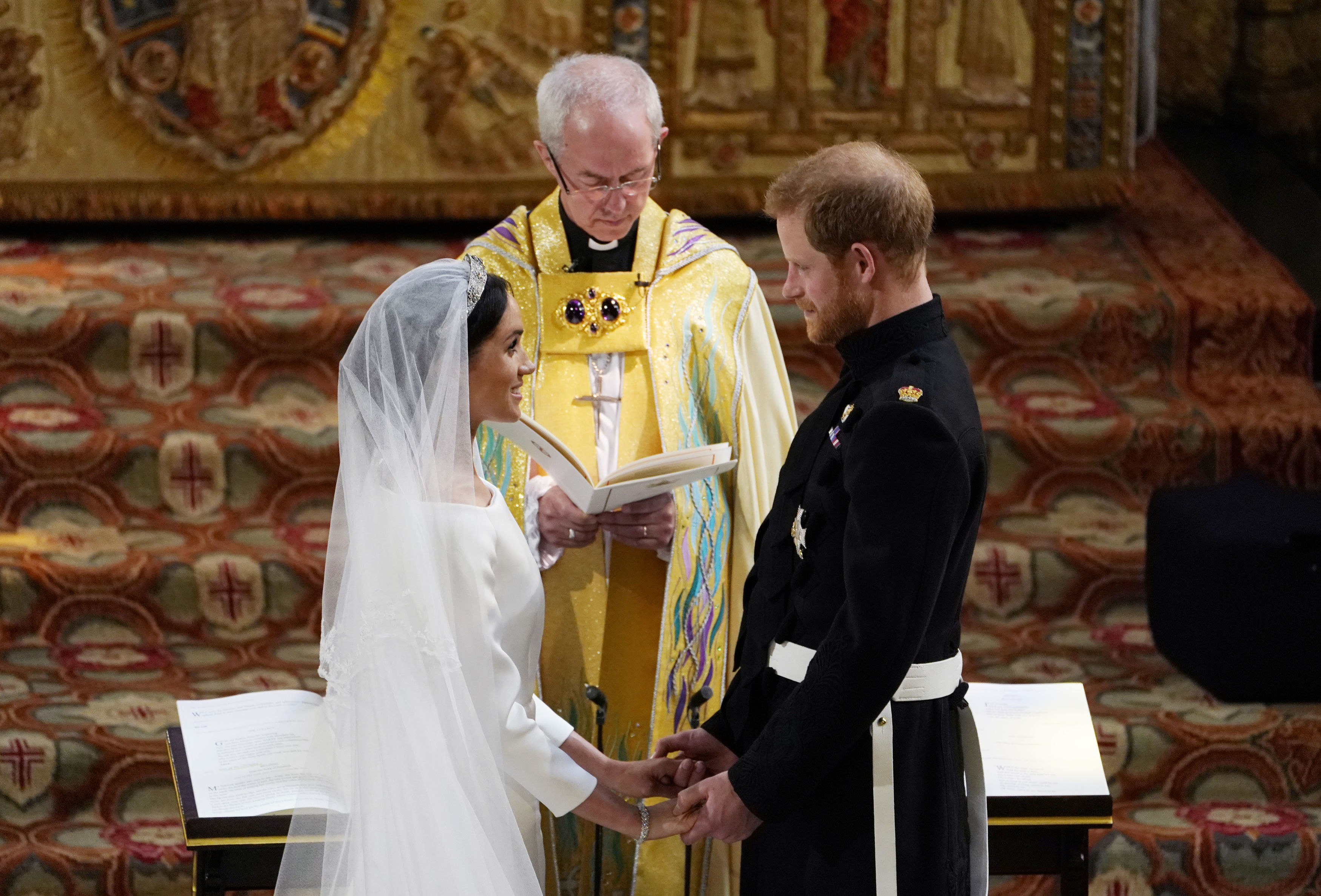 Prince Harry and Meghan Markle stand facing each other in front of Archbishop of Canterbury Justin Welby during wedding ceremony