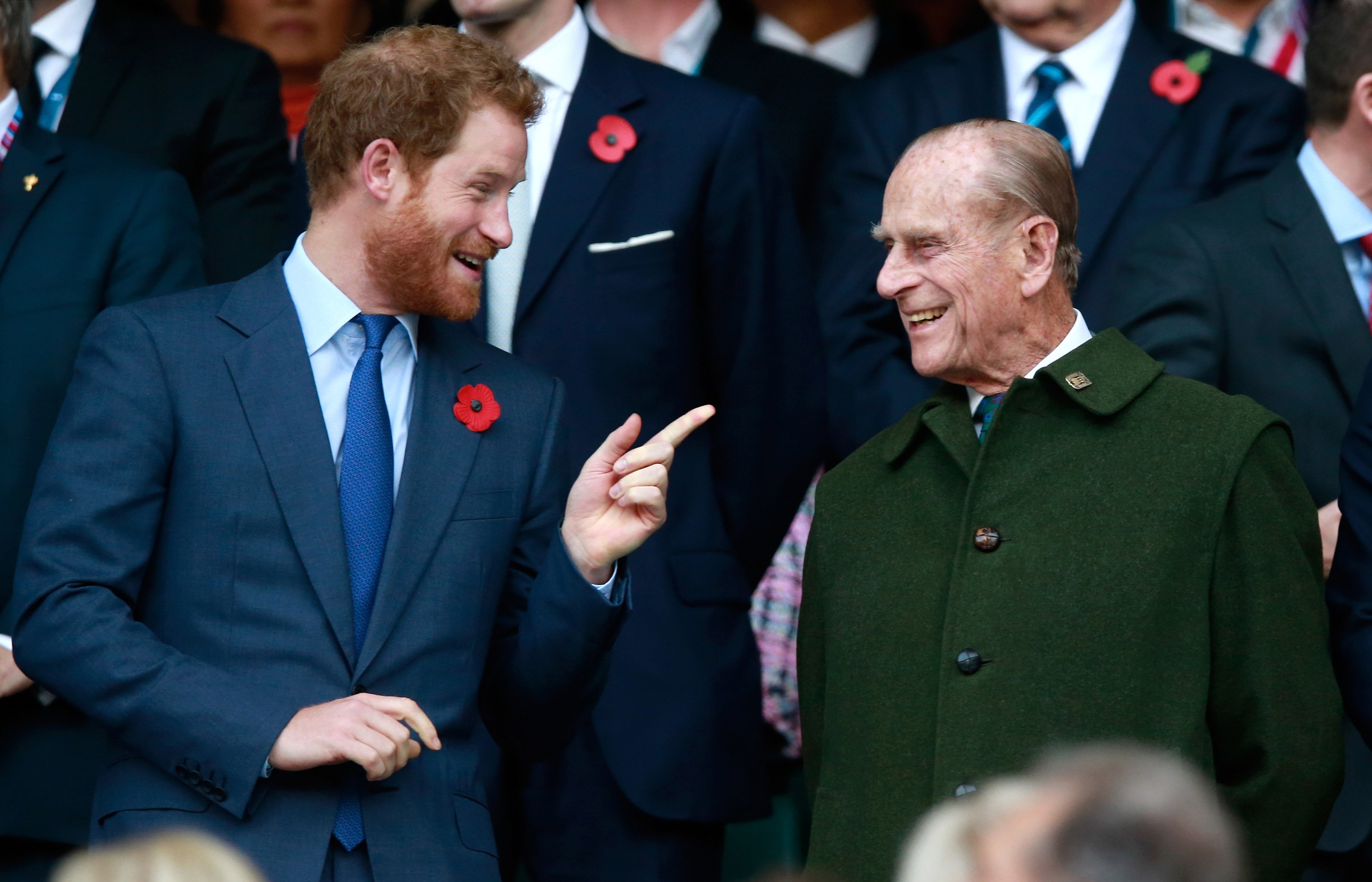 Prince Harry and Prince Phillip laughing together during the 2015 Rugby World Cup Final match