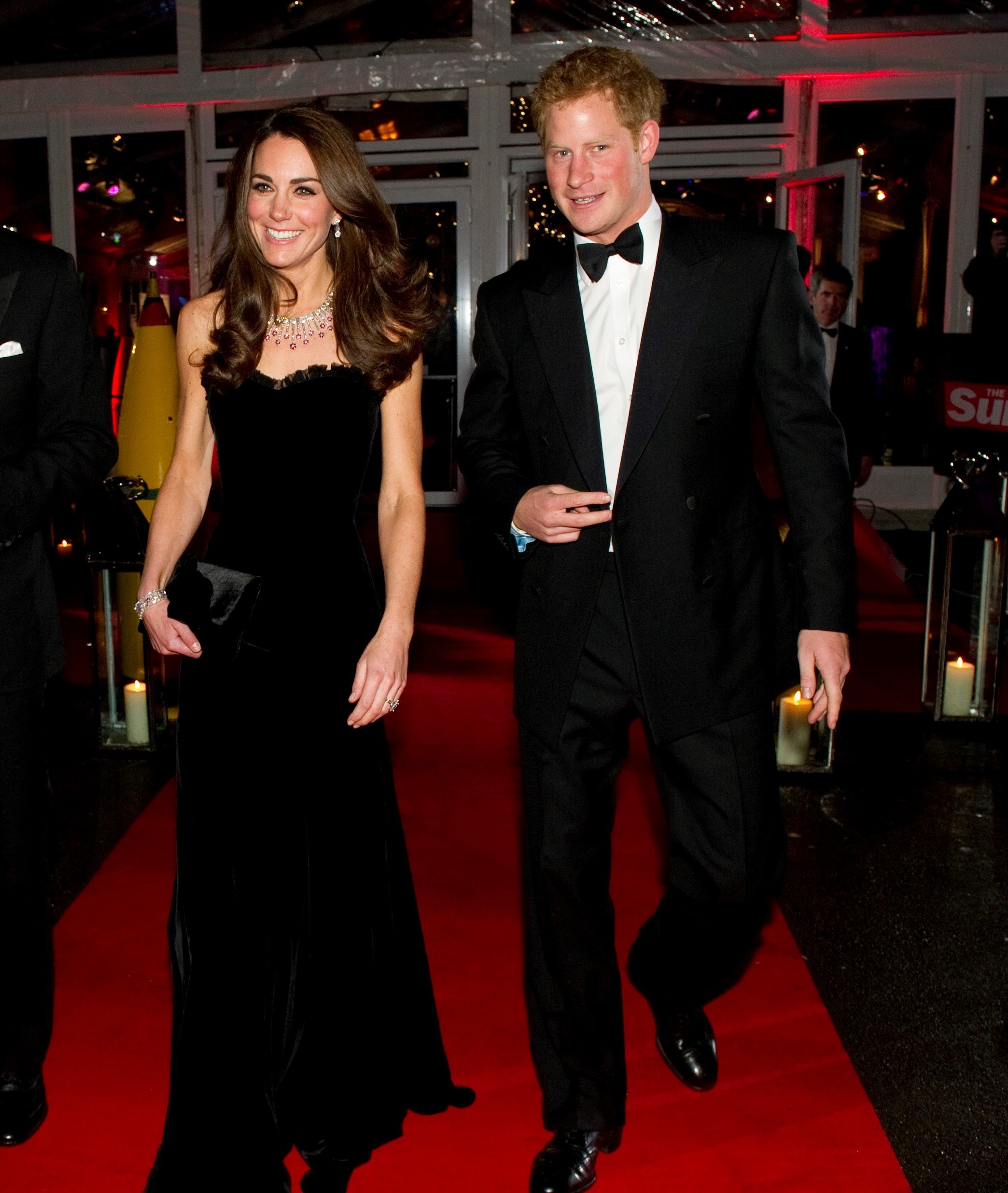 Prince Harry in a tuxedo and Kate Middleton dressed in a black gown at The Sun Military Awards in 2011