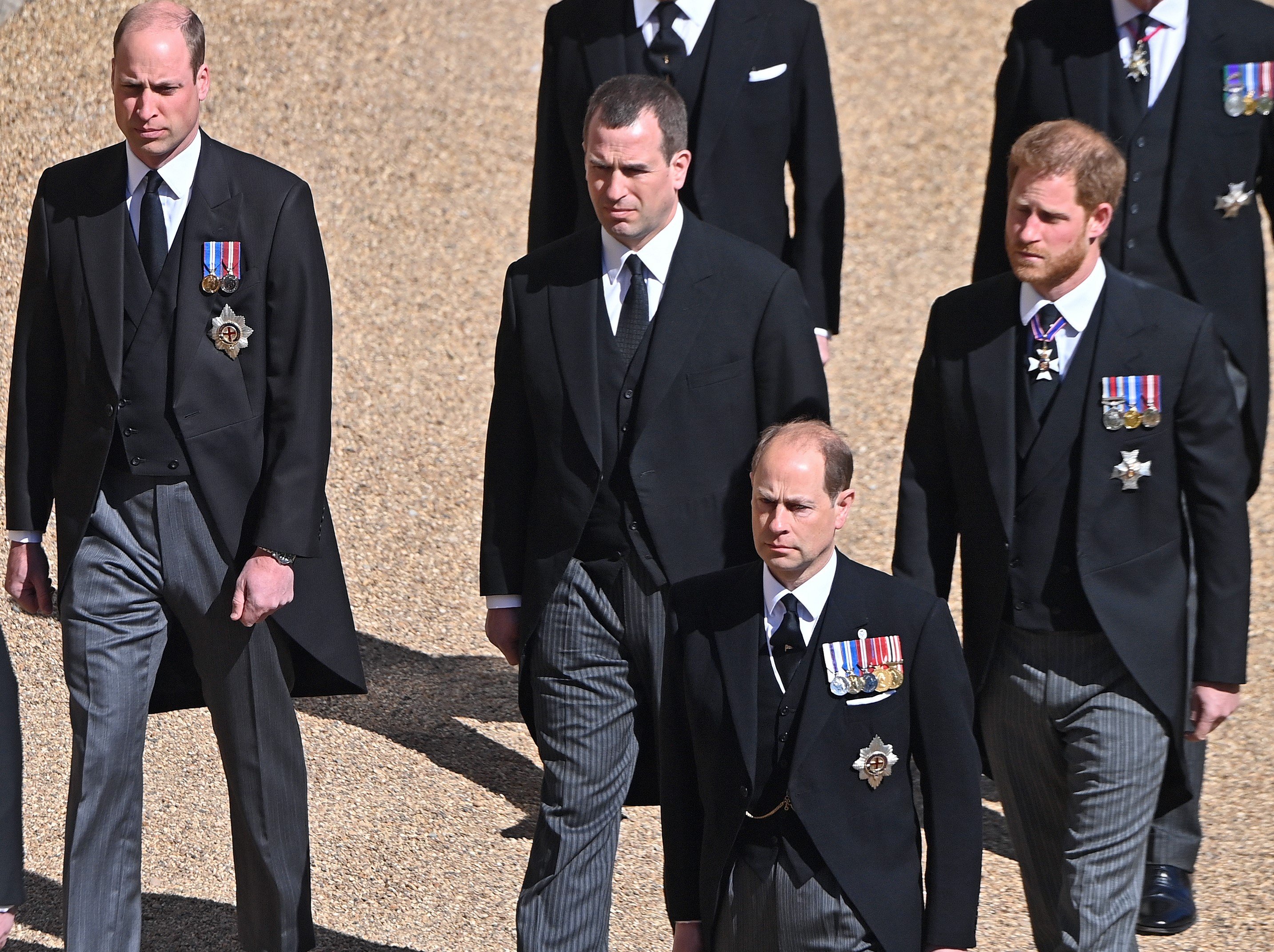 Prince William, Peter Phillips, Prince Edward, Prince Harry, and other family members walk behind Prince Philip’s coffin during his funeral procession at St. George's Chapel on April 17, 2021