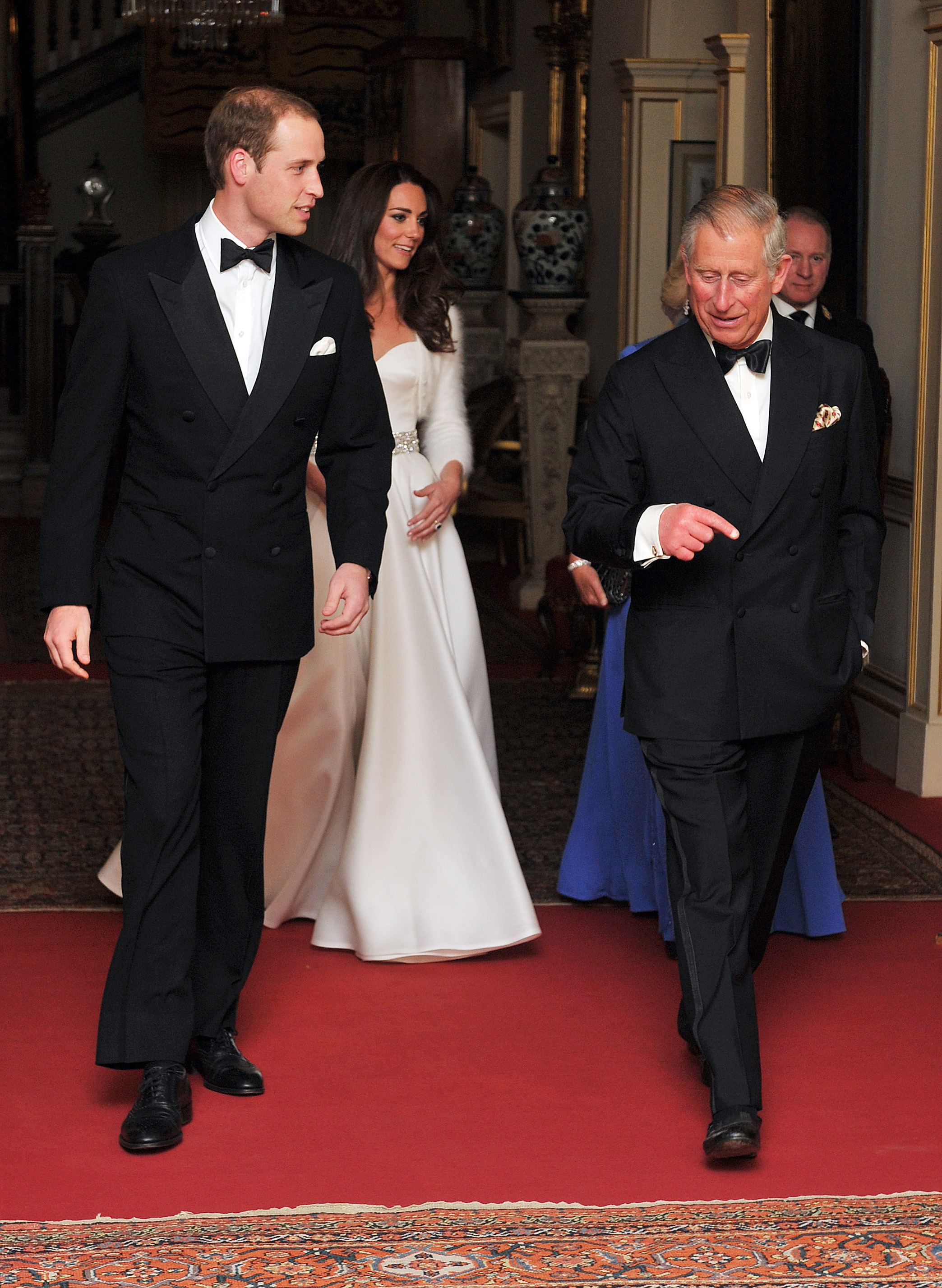 Prince William, Prince Charles, and Kate Middleton walking into Buckingham Palace ballroom for reception