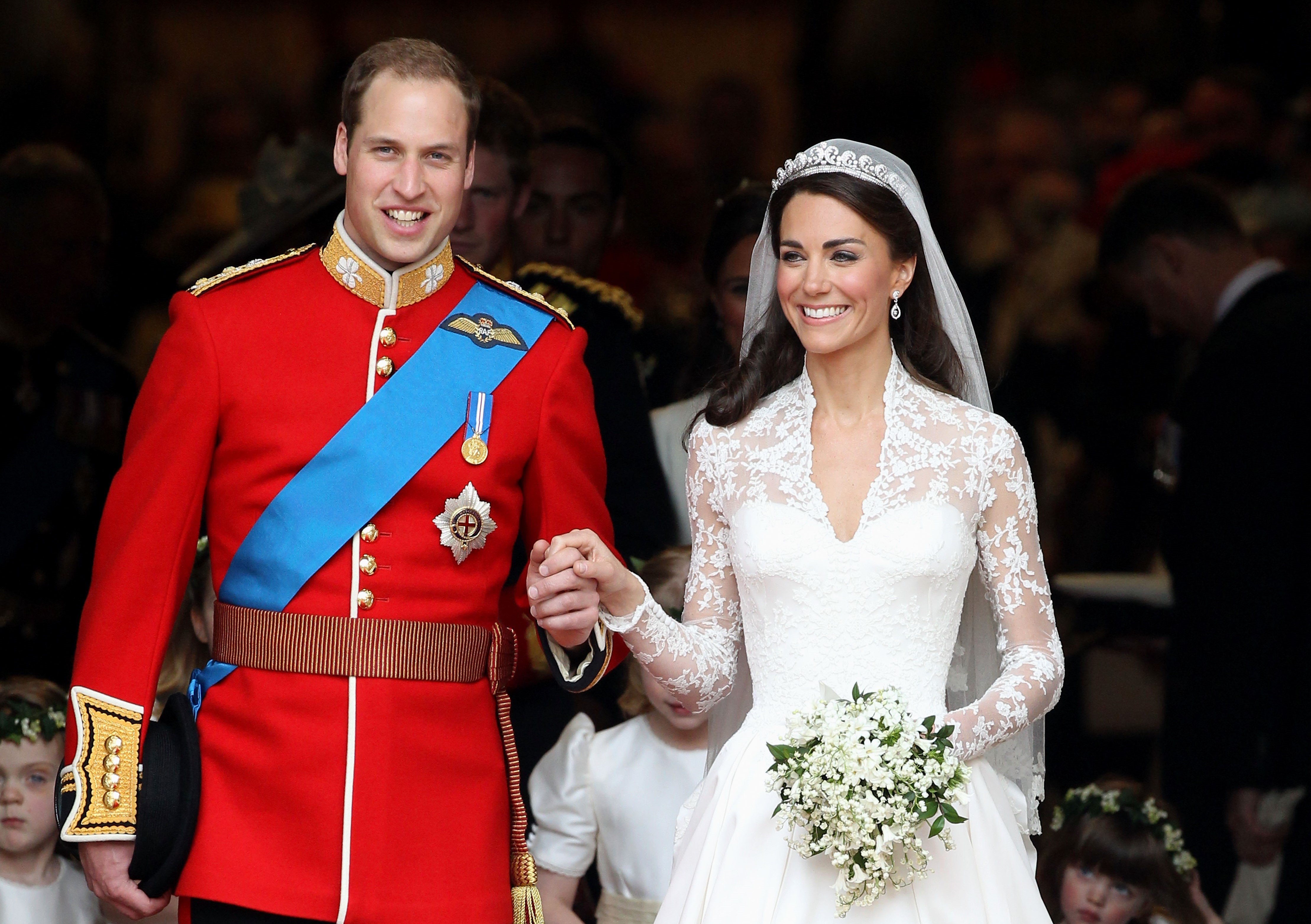 Prince William and Kate Middleton smiling and holding hands following nuptials at Westminster Abbey on April 29, 2011
