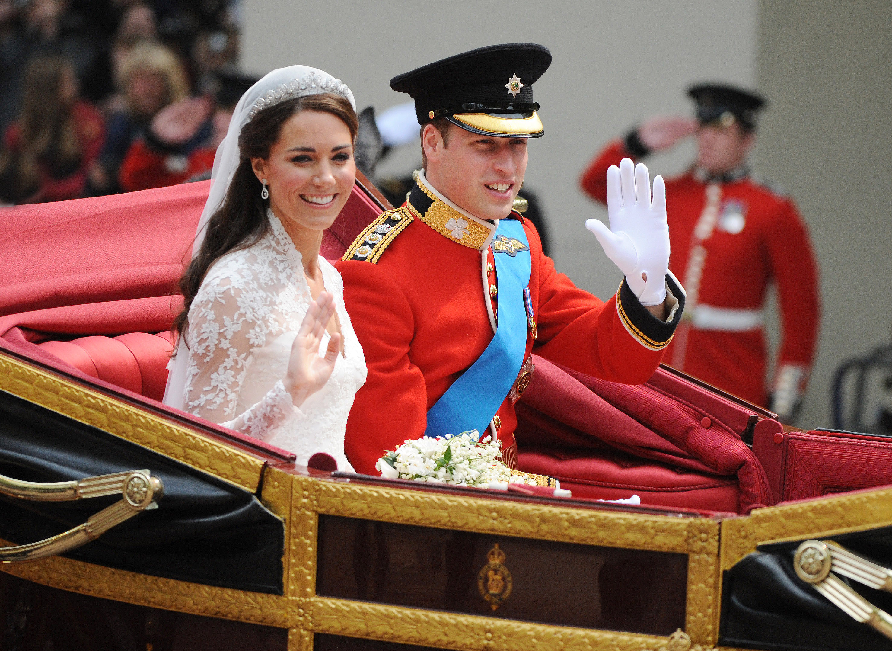 Prince William and Kate Middleton smiling during carriage ride after royal wedding