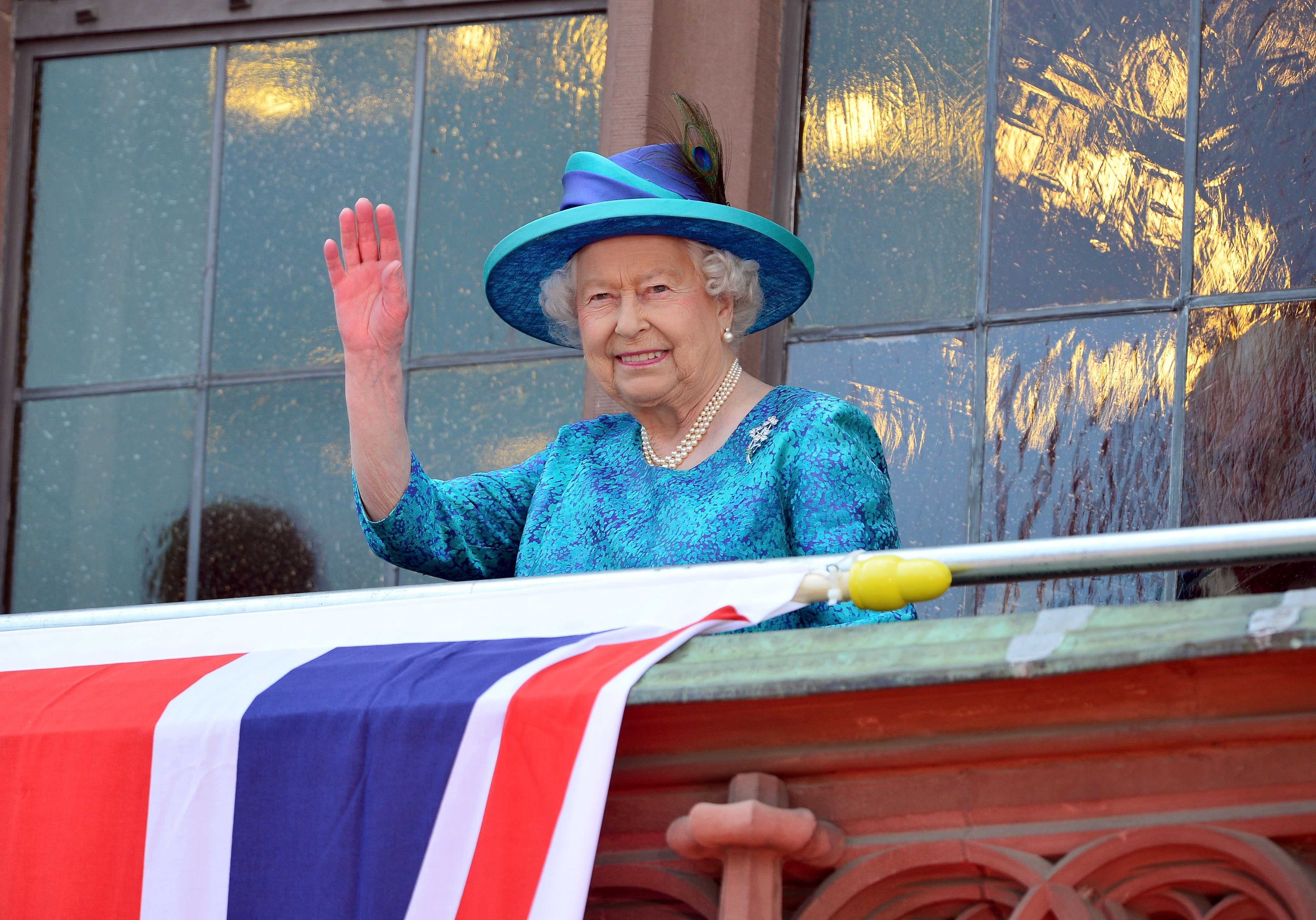 Queen Elizabeth II waves to the crowd from the balcony of the city hall 'Roemer' while visiting Germany