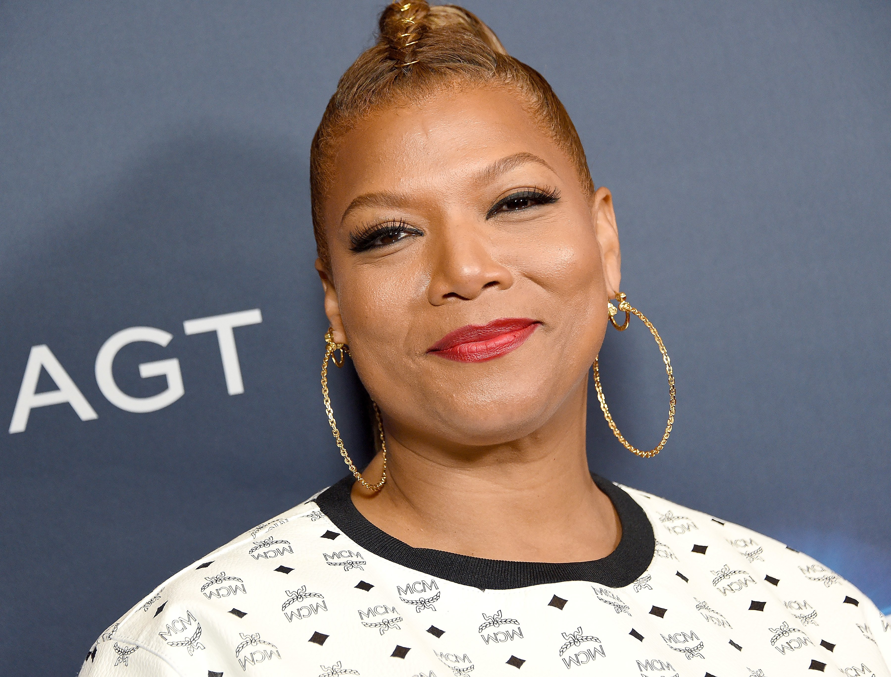 Queen Latifah smiling on the 'America's Got Talent' red carpet.