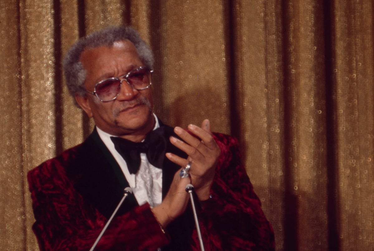 Redd Foxx clapping at a podium