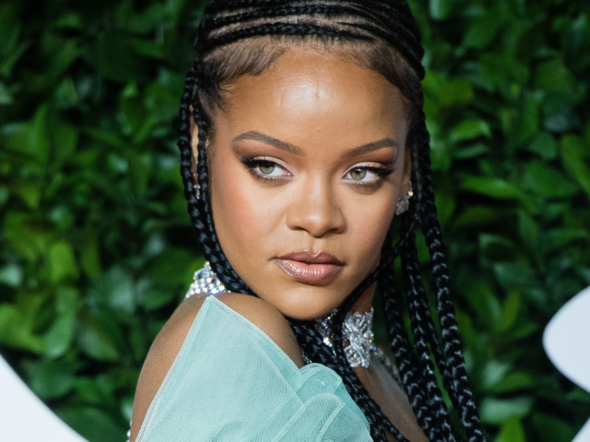 Rihanna in front of a green background