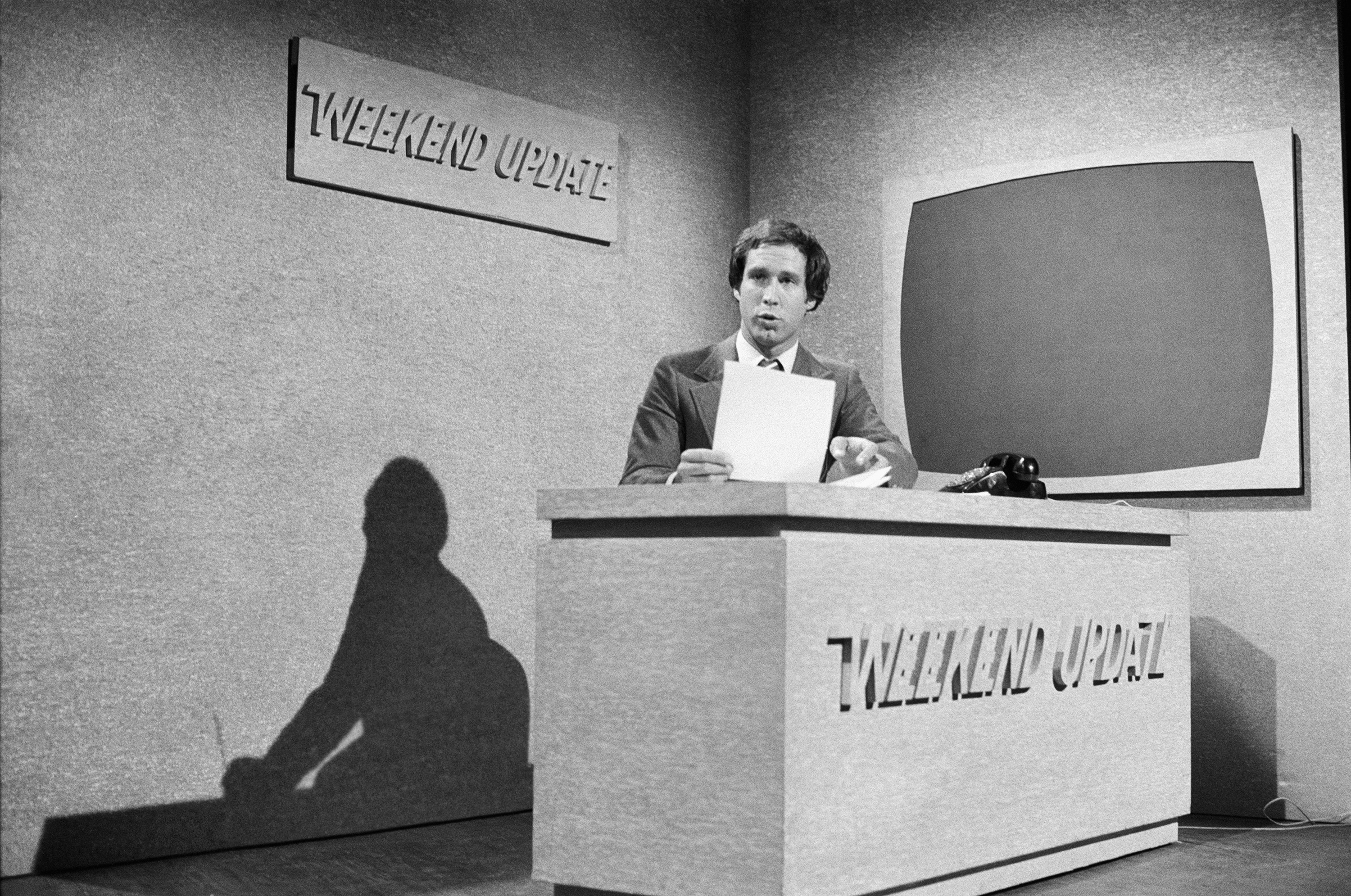 Saturday Night Live Weekend Update anchor Chevy Chase reads the news