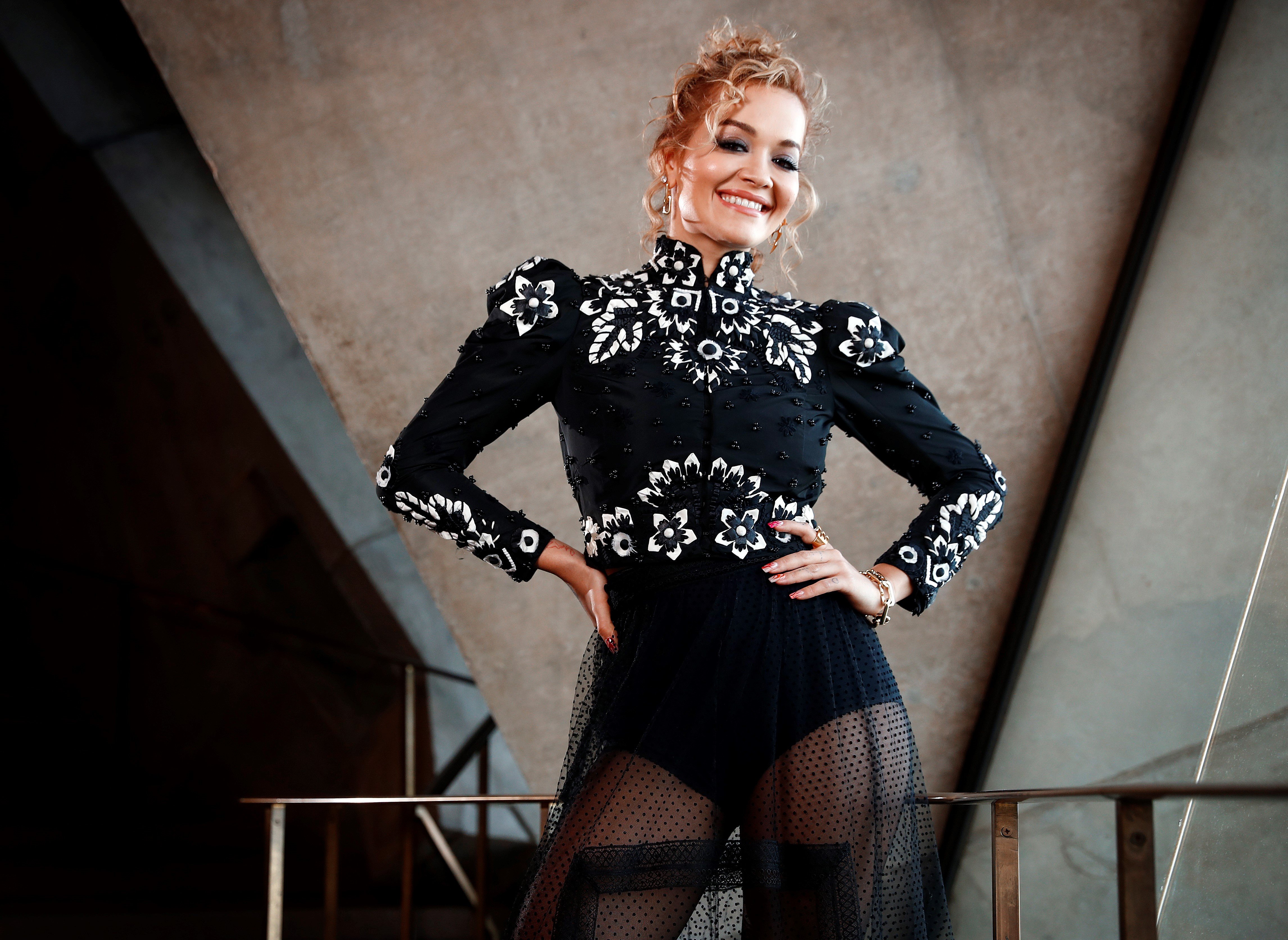 Singer Rita Ora poses in black ensemble during a photo shoot at the Sydney Opera House