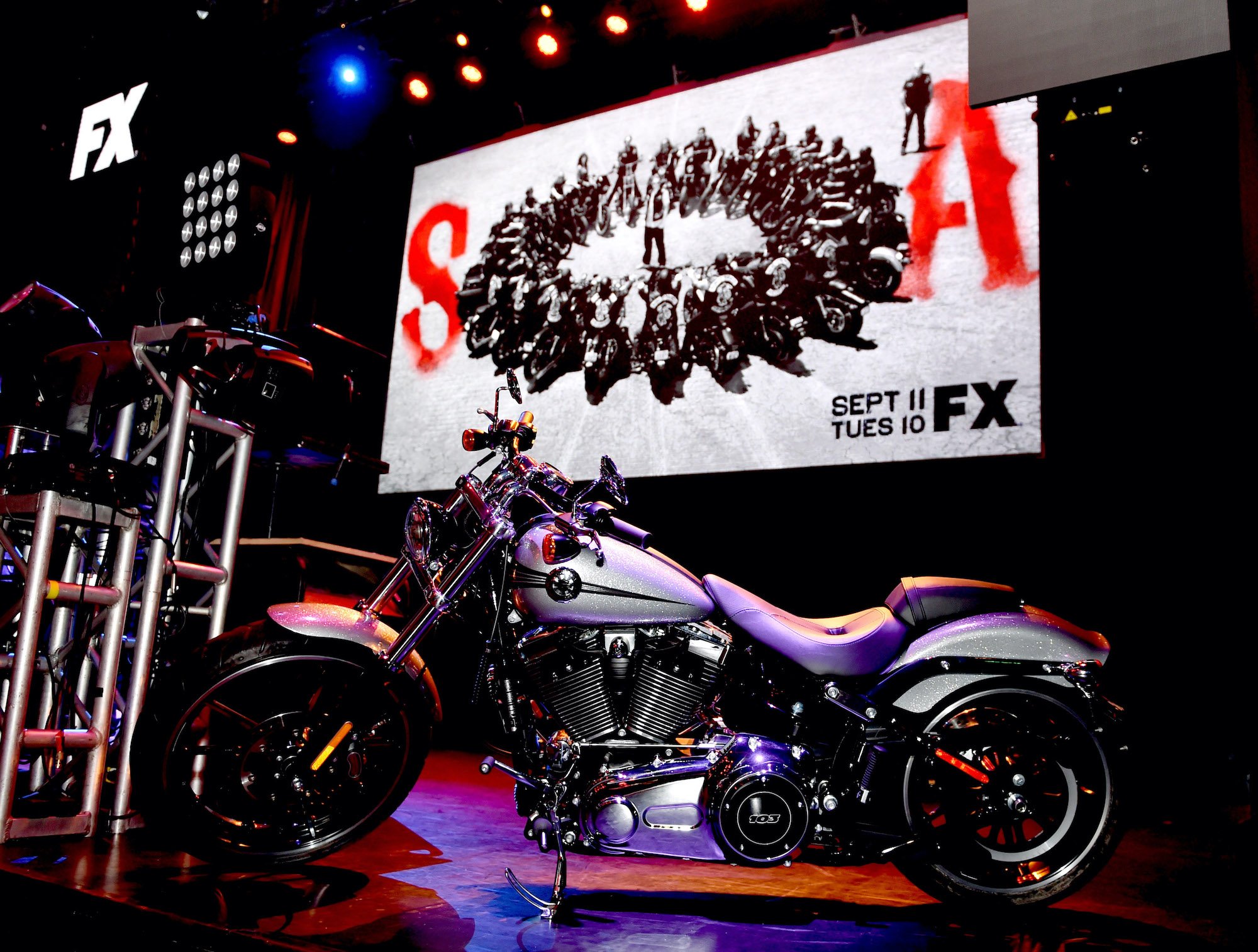 A motorcycle in front of a 'Sons of Anarchy' promo