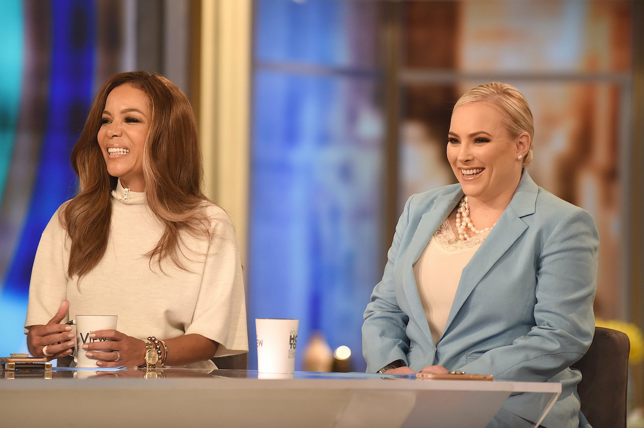 Sunny Hostin and Meghan McCain smiling at the table of 'The View'
