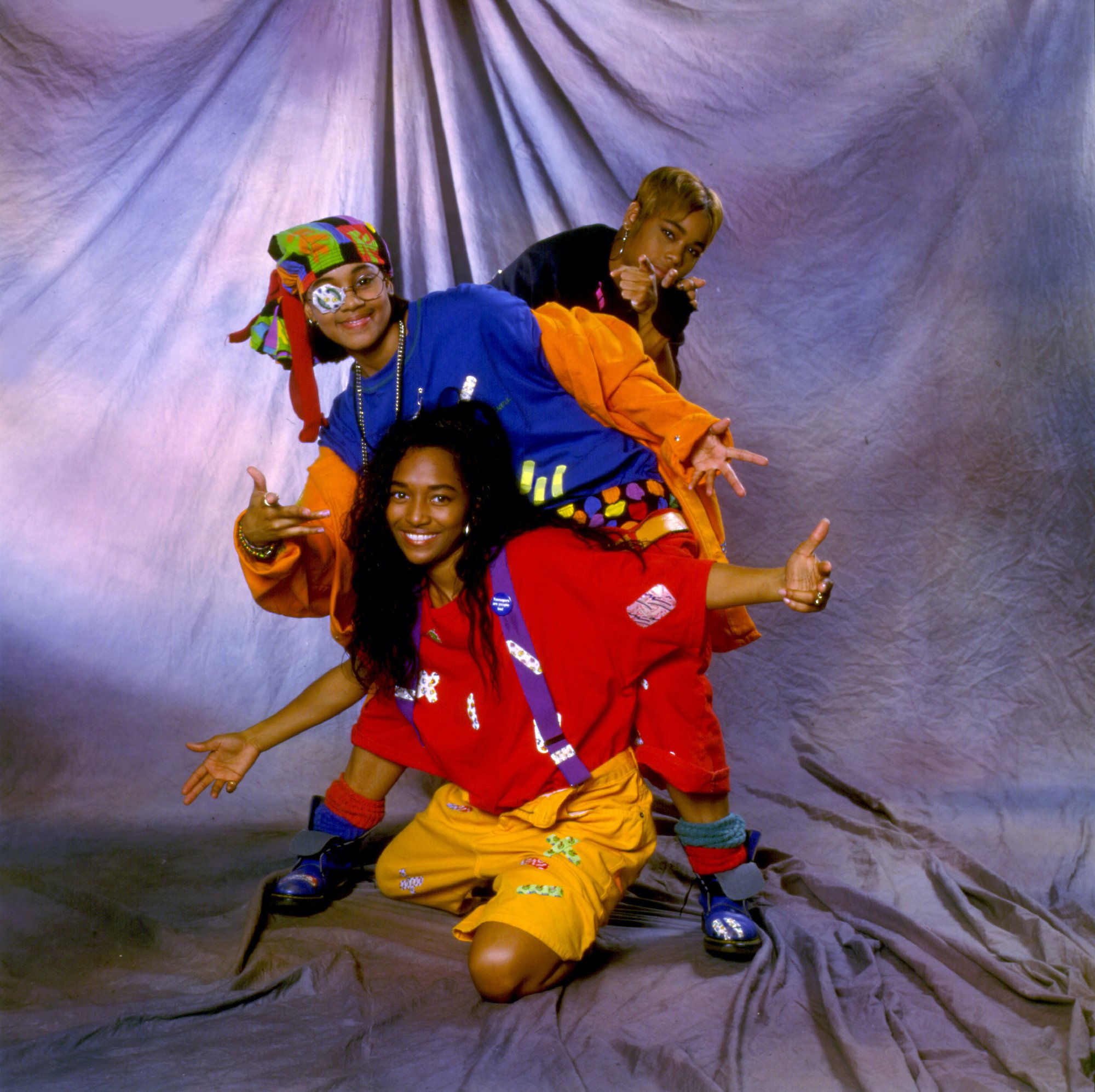 TLC in front of a tie dye backdrop