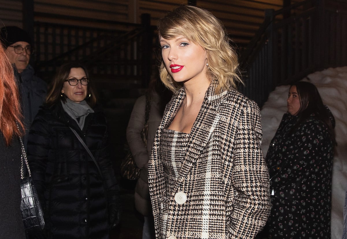 Taylor Swift in a plaid jacket and bright red lipstick