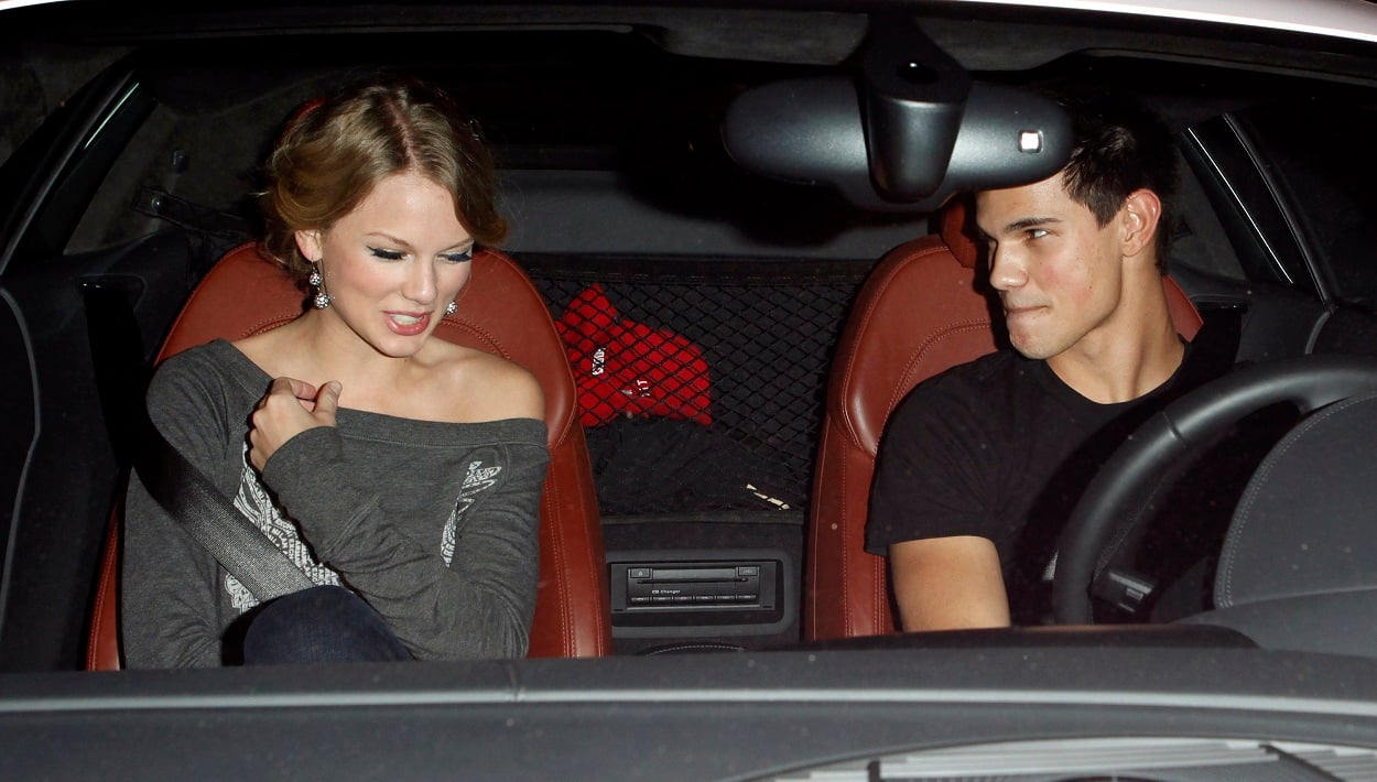 Taylor Swift and Taylor Lautner smile flirtatiously at one another while in a car