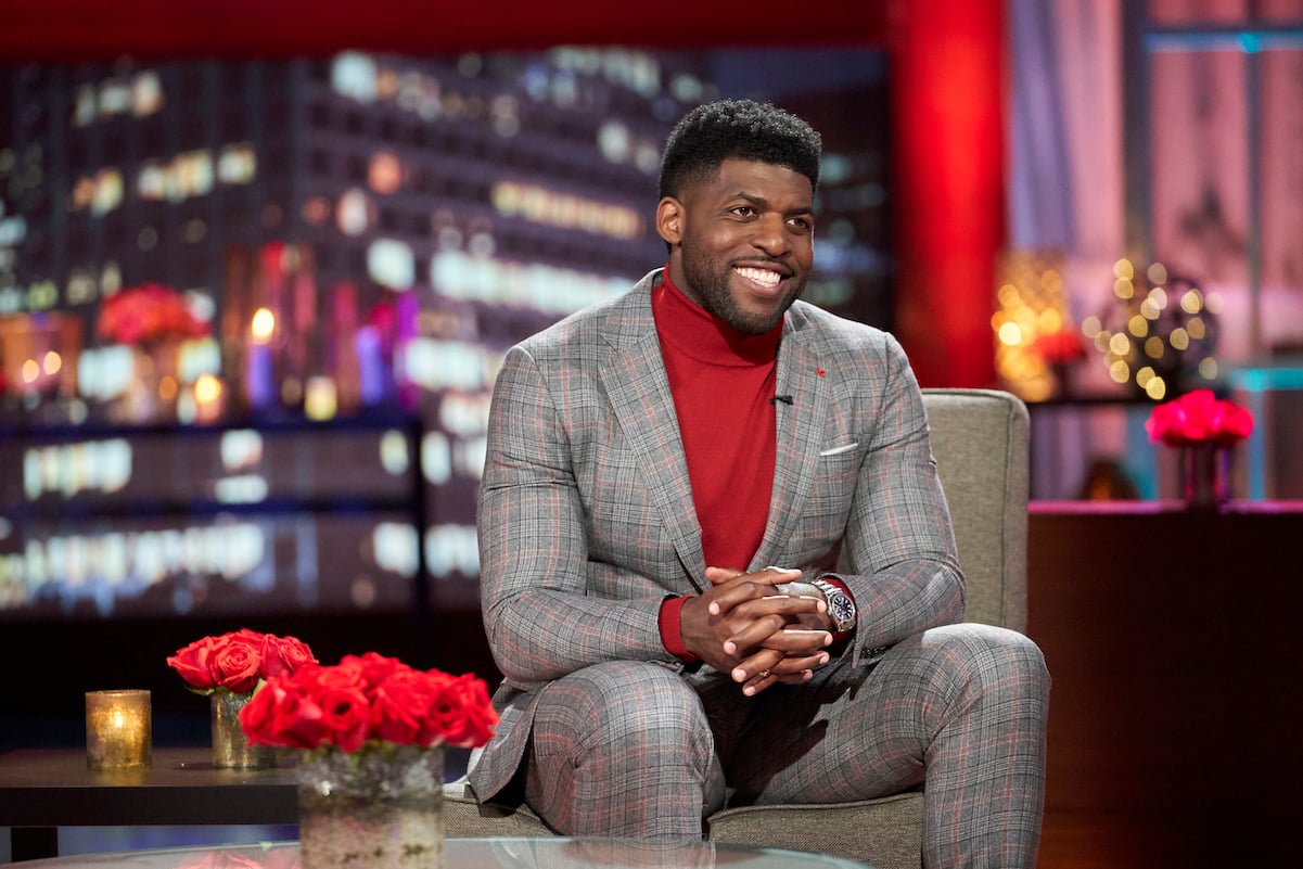 Emmanuel Acho hosting 'The Bachelor: After the Final Rose' sitting and smiling