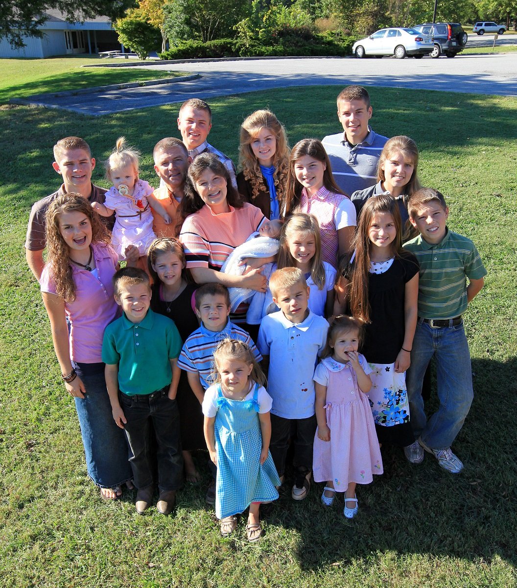 The Bates family smiles at the camera in front of their Tennessee home