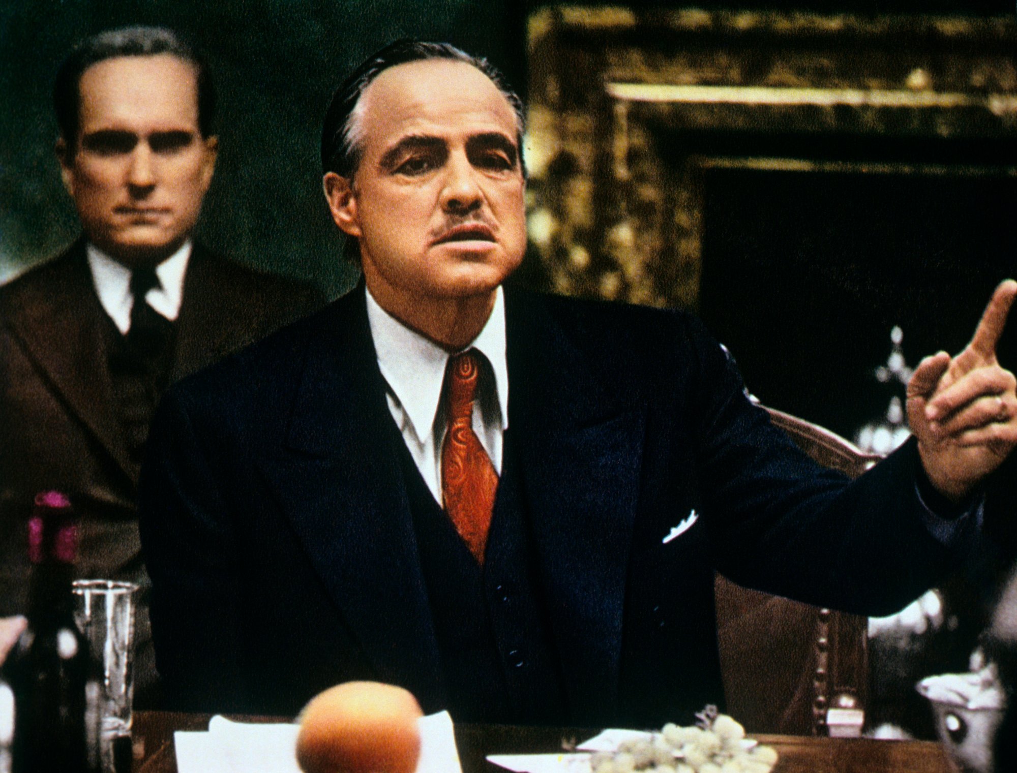 Marlon Brando in The Godfather sitting at a table