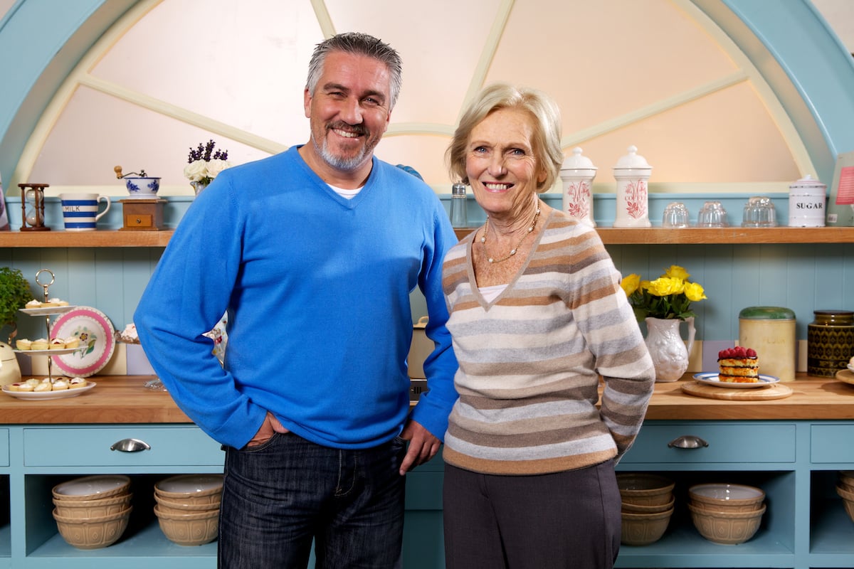 Paul Hollywood and Mary Berry smile as they stand next to each other in the tent for 'The Great British Baking Show