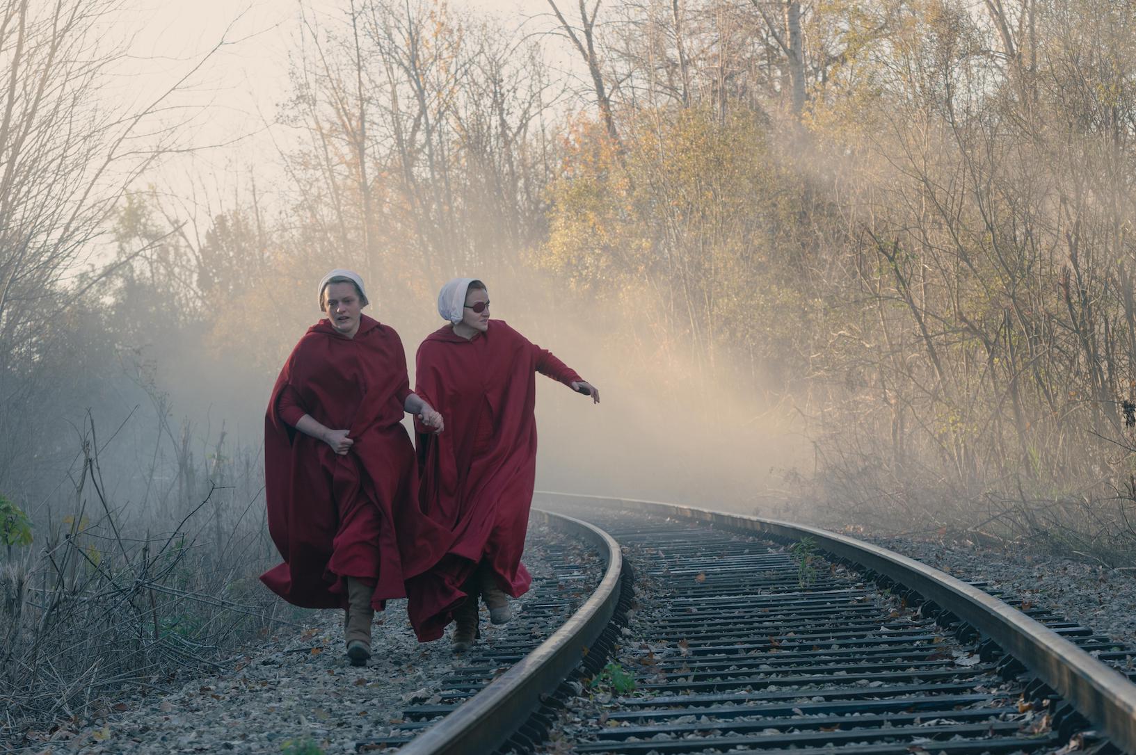 Two of the handmaids running along train tracks in 'The Handmaid's Tale' Season 4