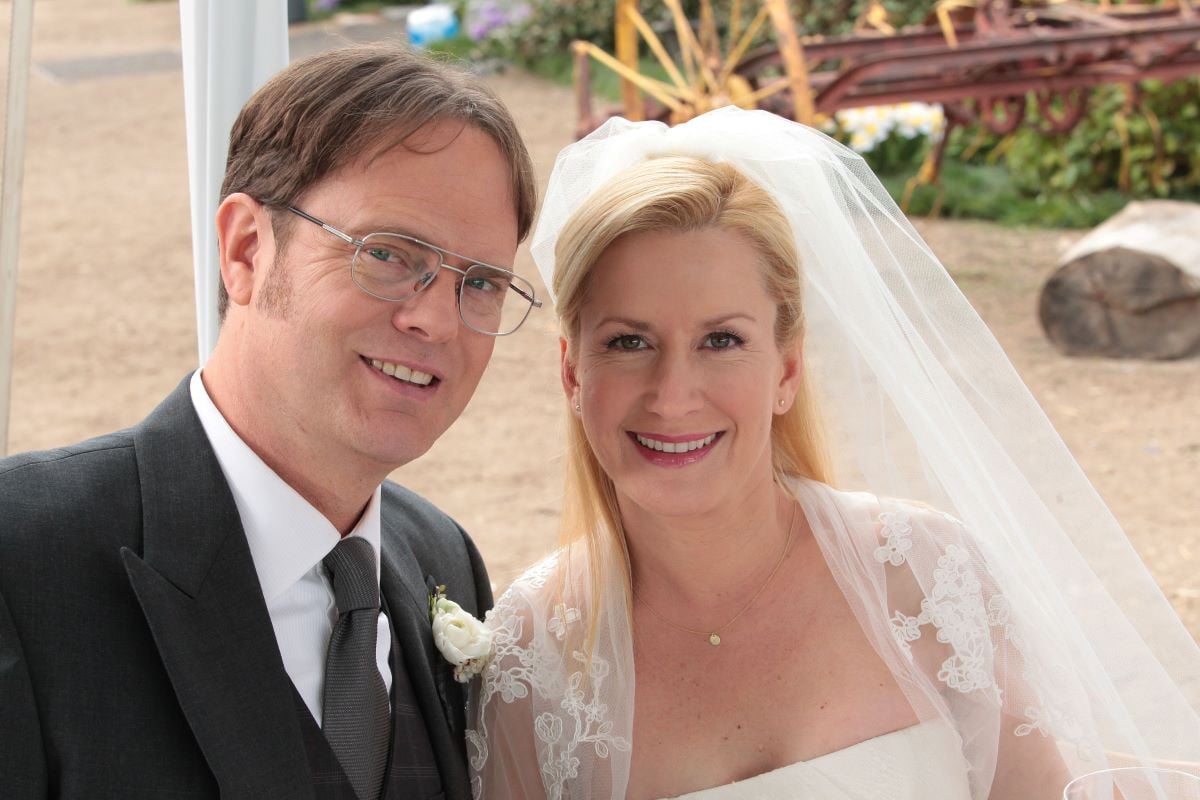 Rainn Wilson as Dwight Schrute poses in a suit and Angela Kinsey as Angela Martin poses in a wedding dress on 'The Office'