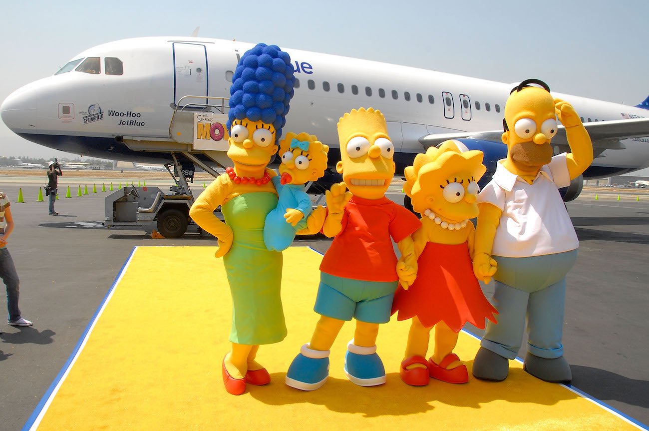 The Simpsons characters standing in front of airplane