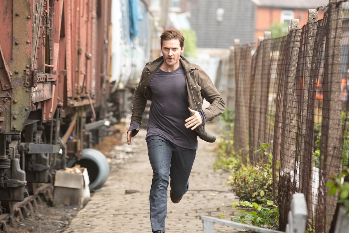 Richard Armitage running down an alley in The Stranger