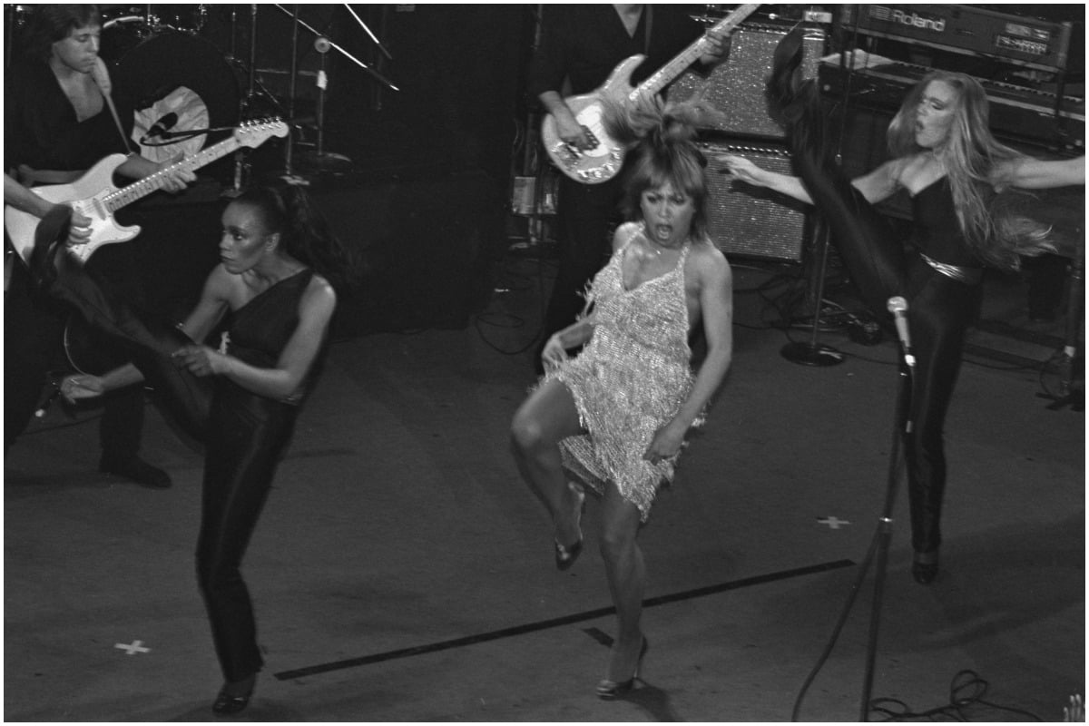 A black and white photo of Tina Turner dancing on tour.