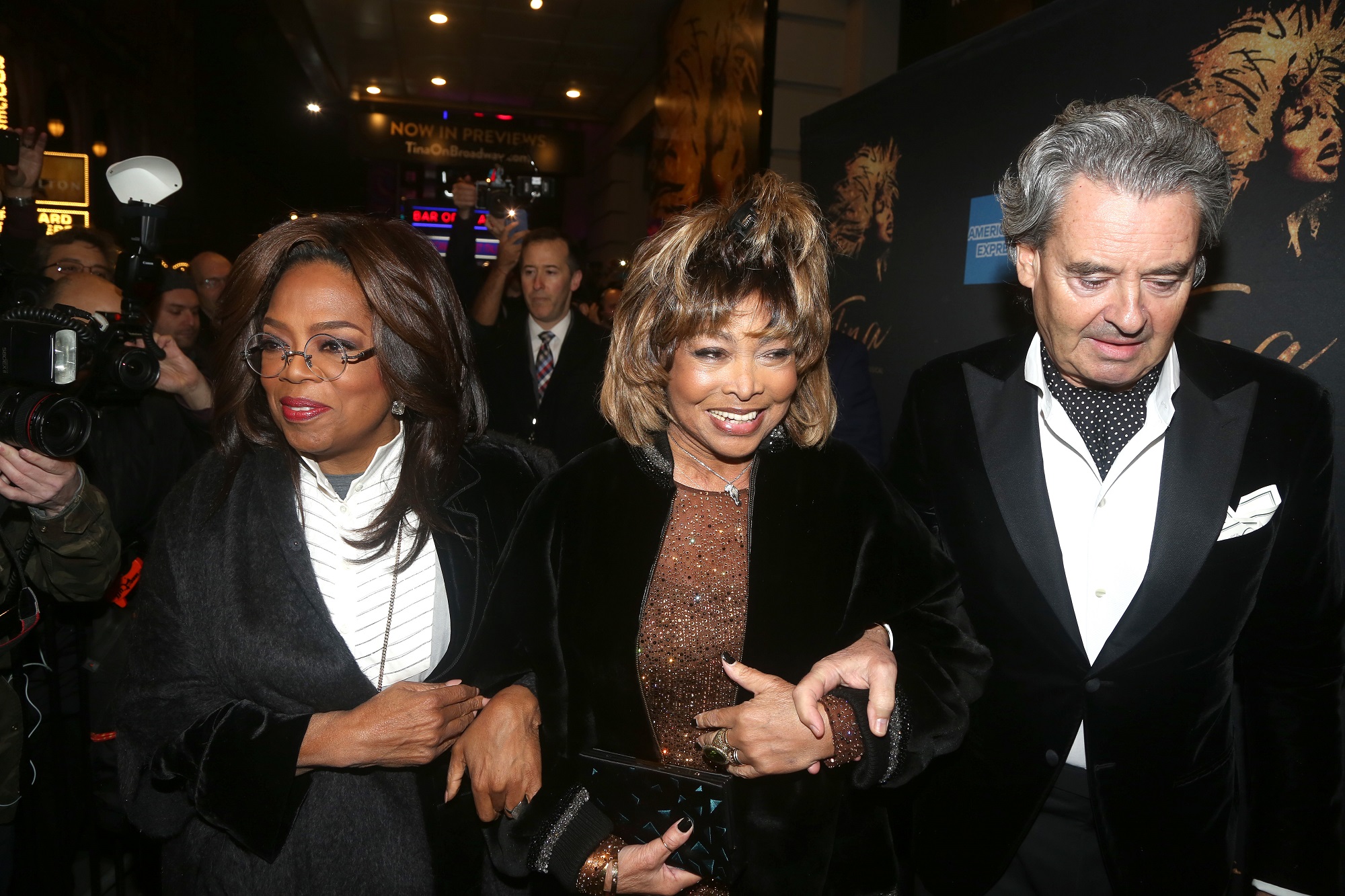 Tina Turner walks between Erwin Bach and Oprah Winfrey