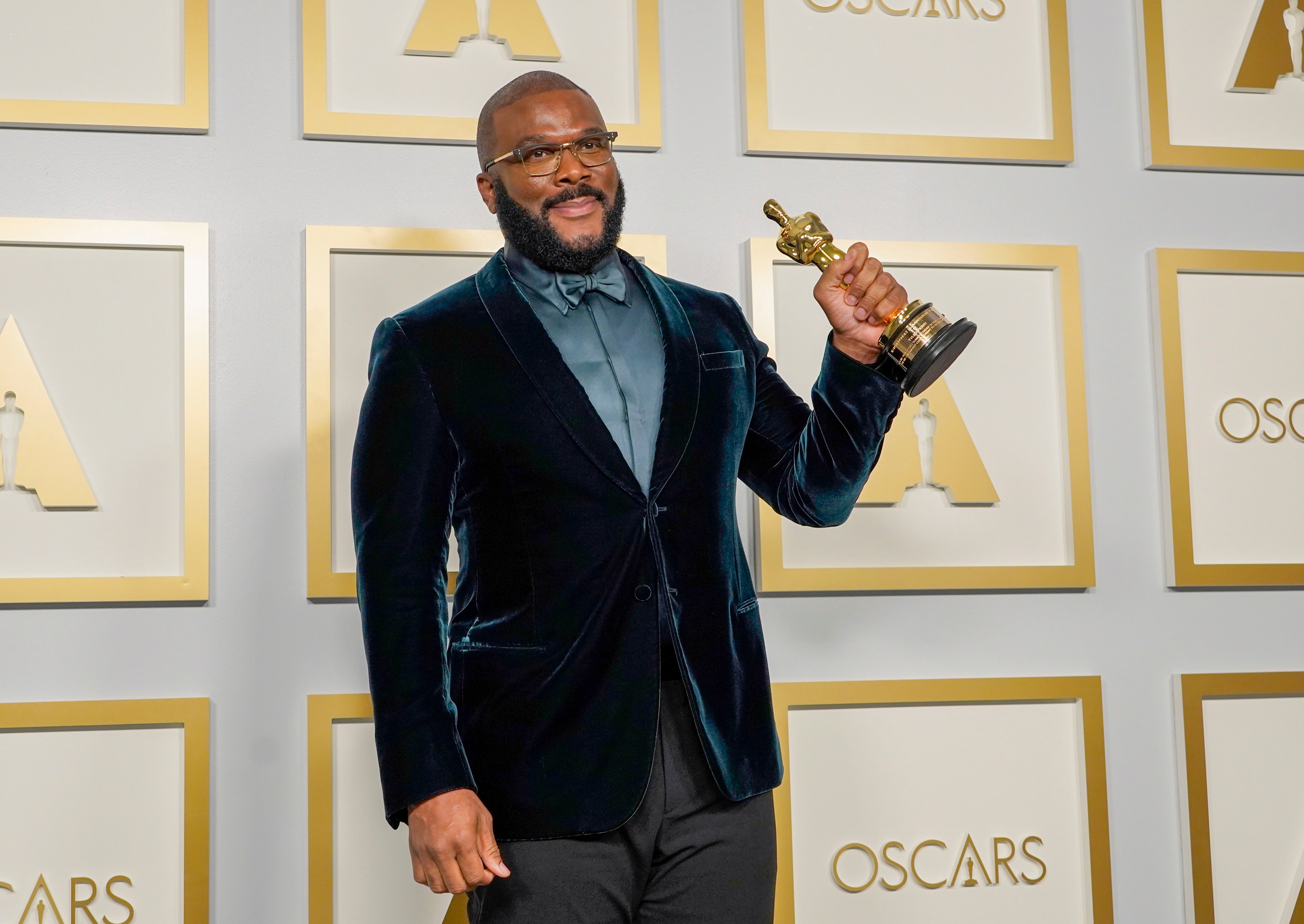 Tyler Perry poses with his hardware in press room at 93rd Oscars after winning humanitarian award