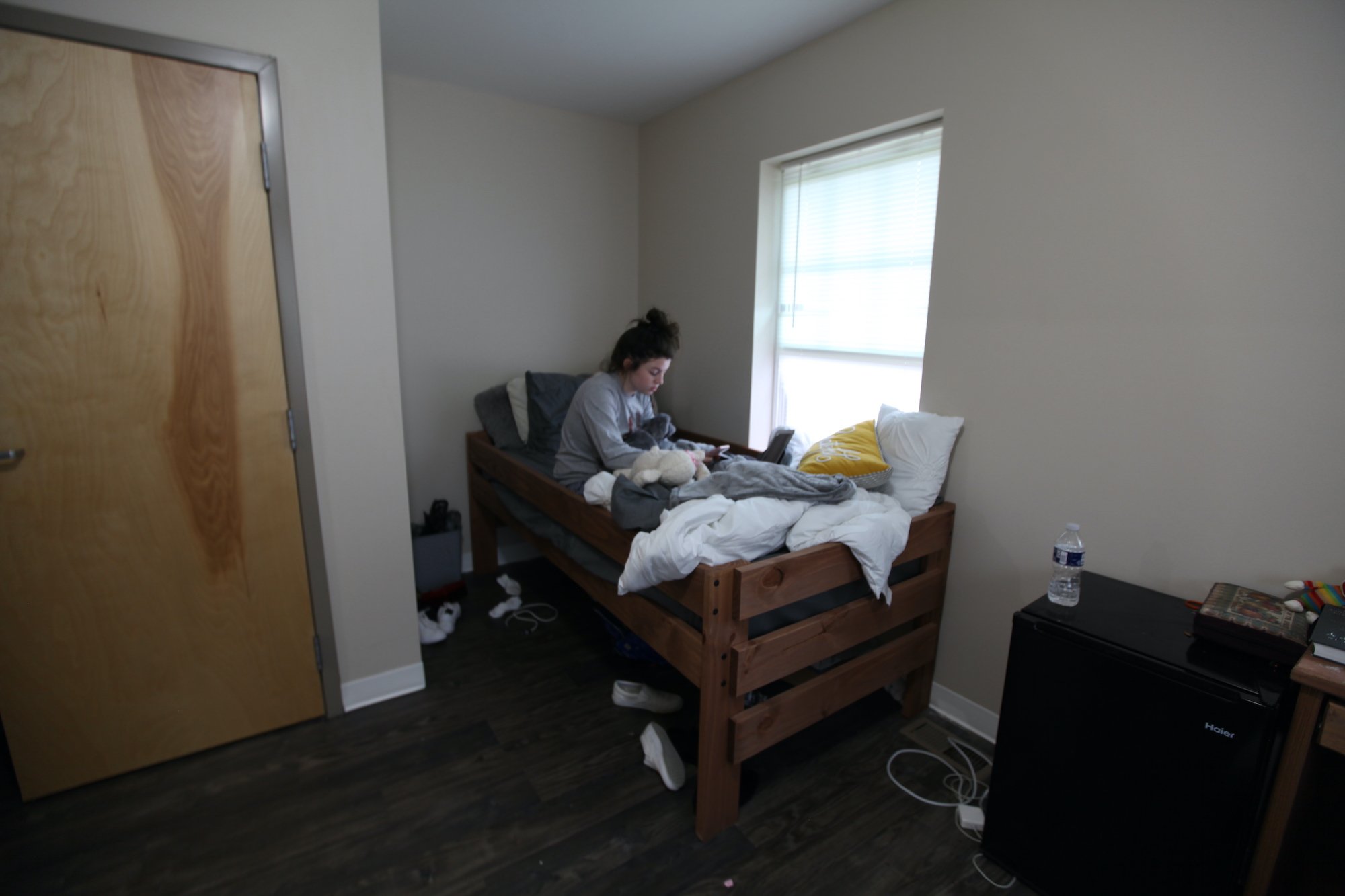 A girl sitting on a dorm bed