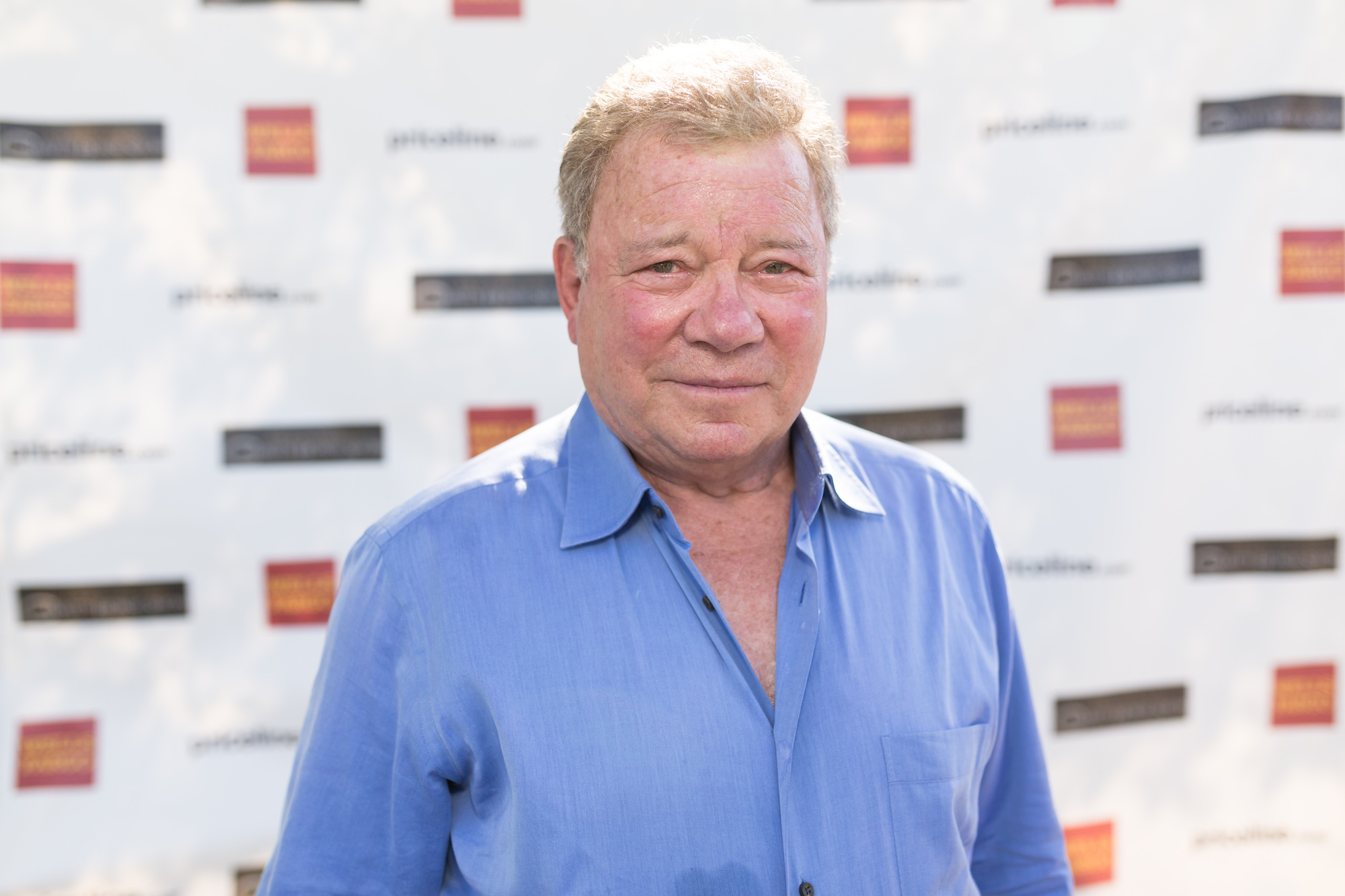 William Shatner smiling in front of a white background