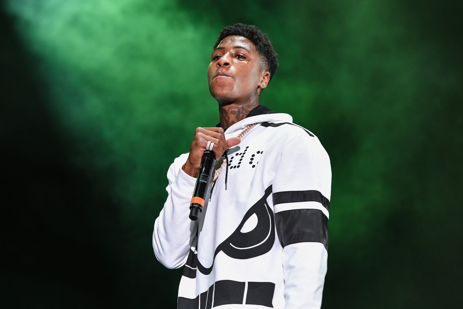 NBA Youngboy standing on stage with the microphone at his chest
