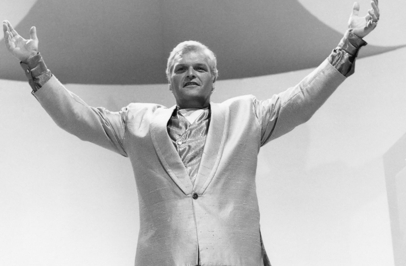 Brian Dennehy holds his hands to the sky in character as a preacher on 'Miami Vice'