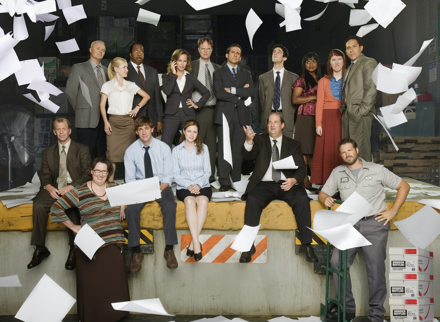 The cast of 'The Office' pose in character and paper falls from above.