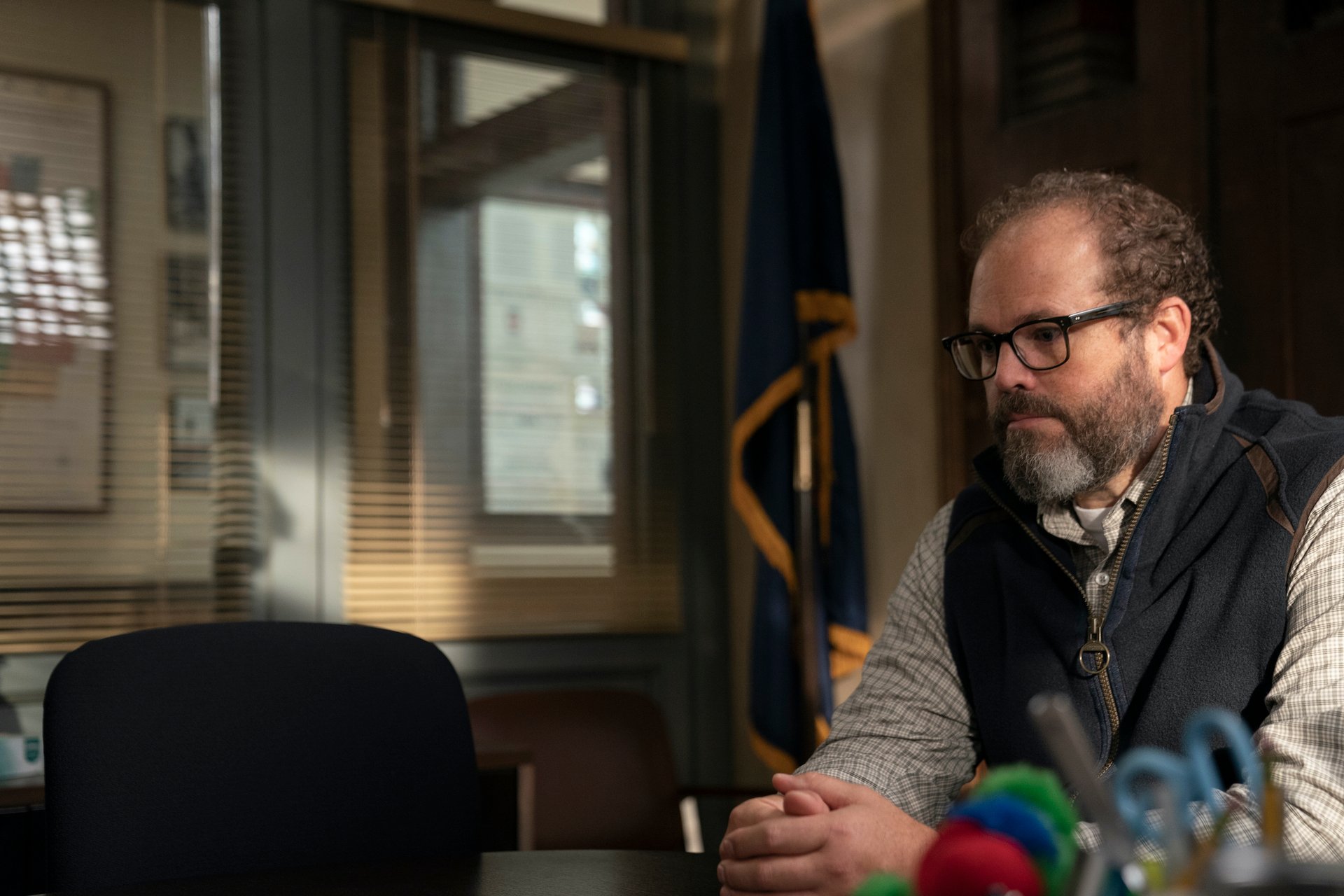 david denman sitting at a table in mare of easttown