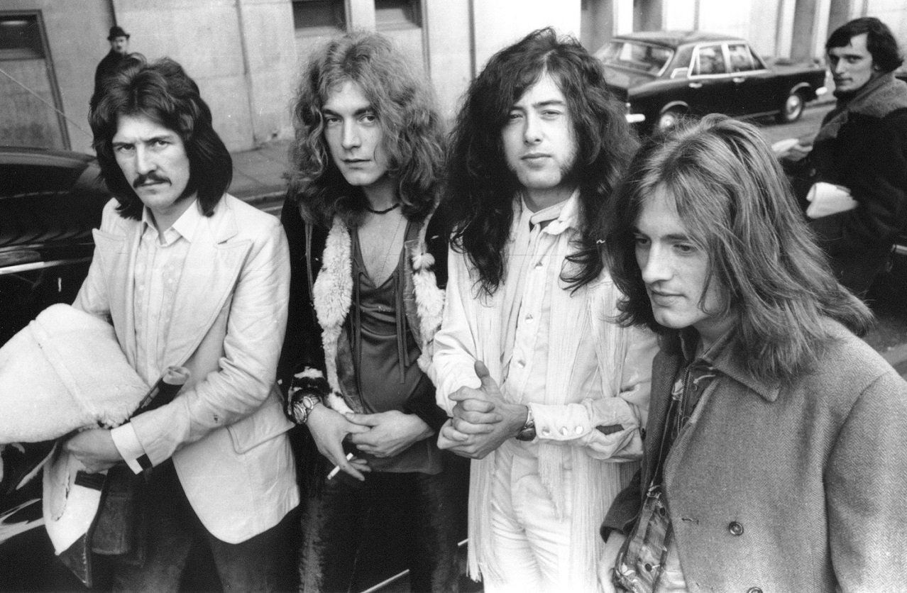 The four members of Led Zeppelin, none of them smiling, on a street