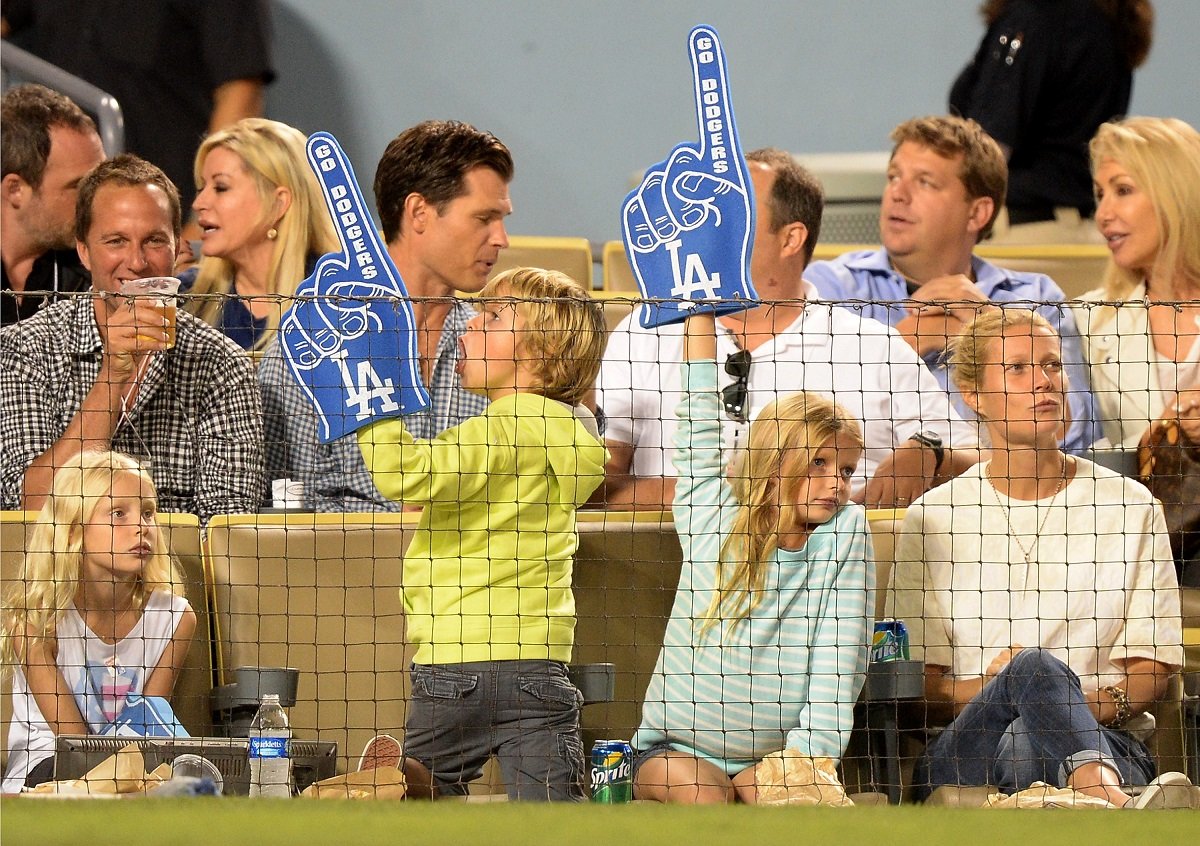 Gwyneth Paltrow (far R) with Moses and Apple Martin (L-R with foam fingers) on September 11, 2013, in Los Angeles, California.