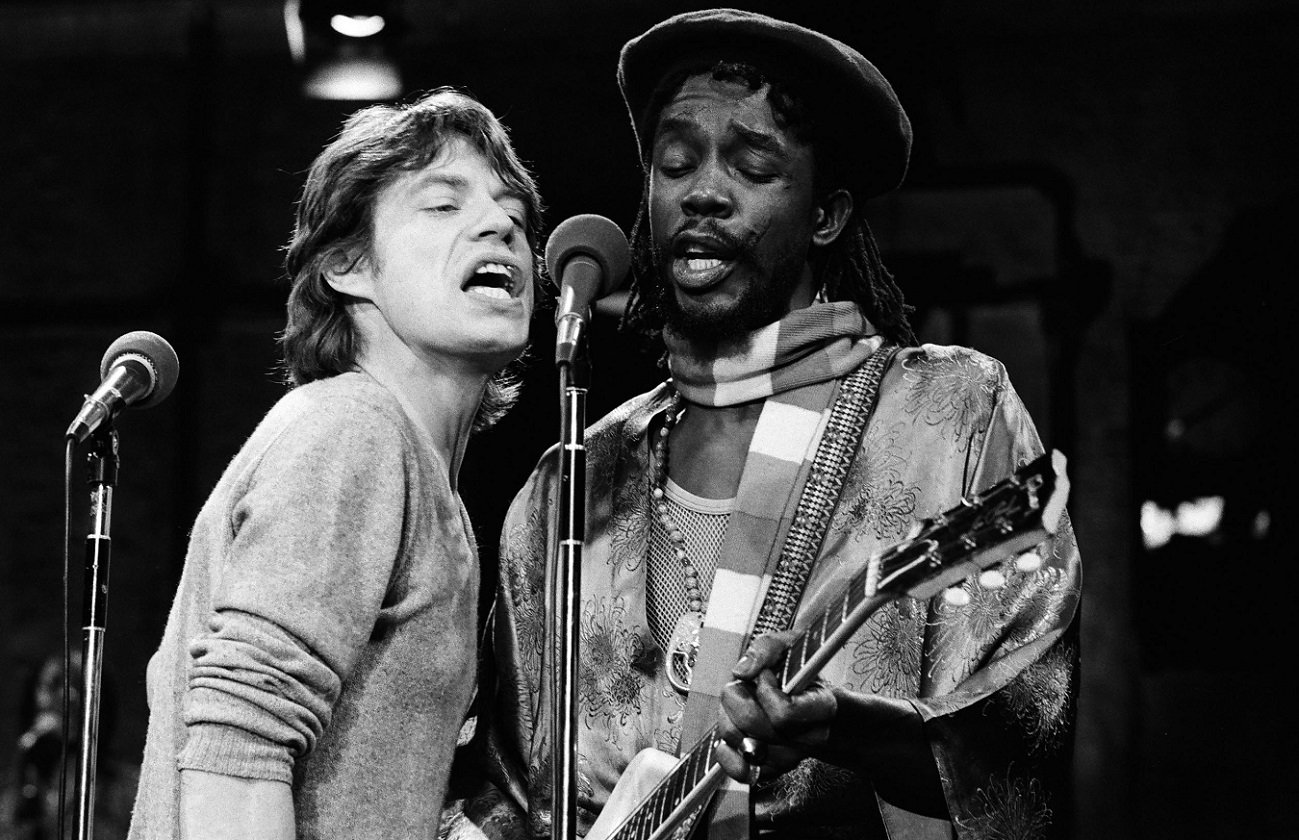 Mick Jagger and Peter Tosh sing into the microphone on the 'SNL' set