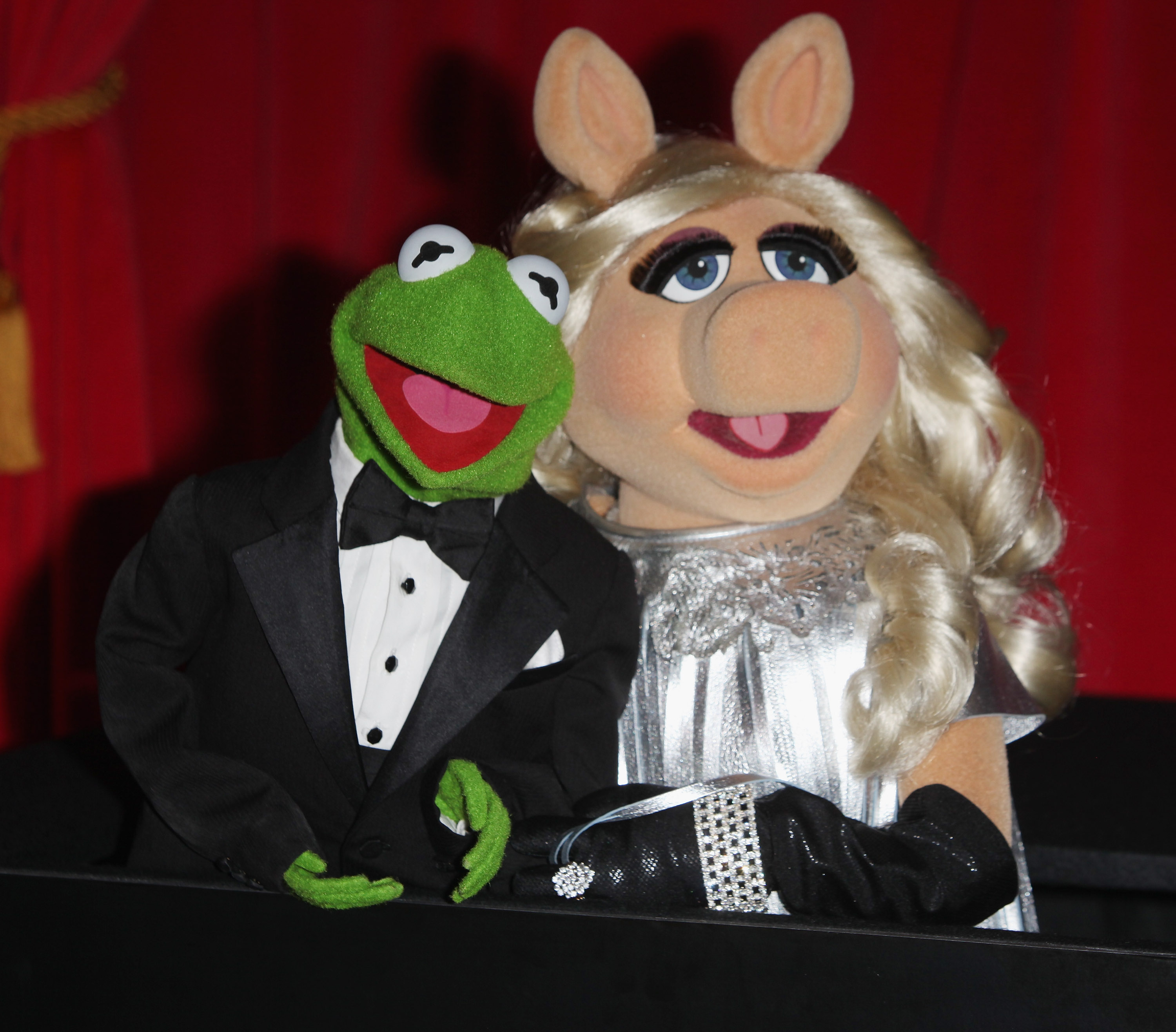 Kermit the Frog and Miss Piggy leaning on each other