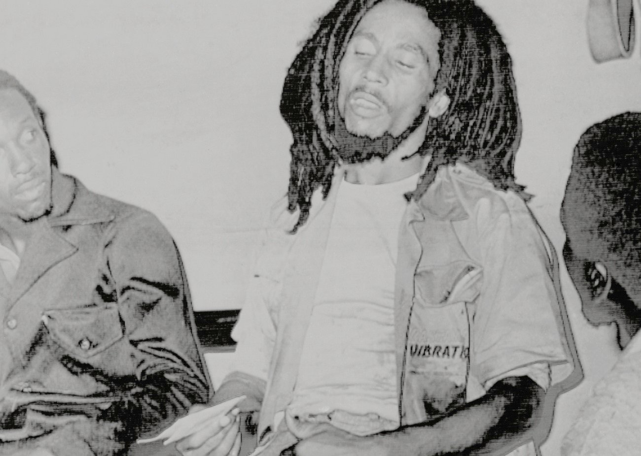 Bob Marley sits in the hospital, bloodied following his shooting