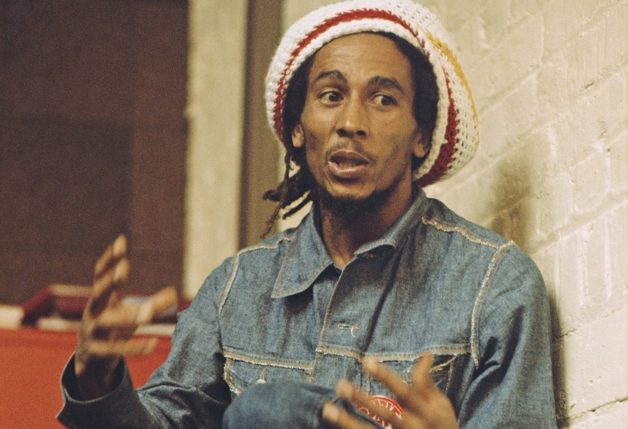 Bob Marley pictured wearing a denim jacket, jeans, and a cap at the offices of Island Records, July 1975