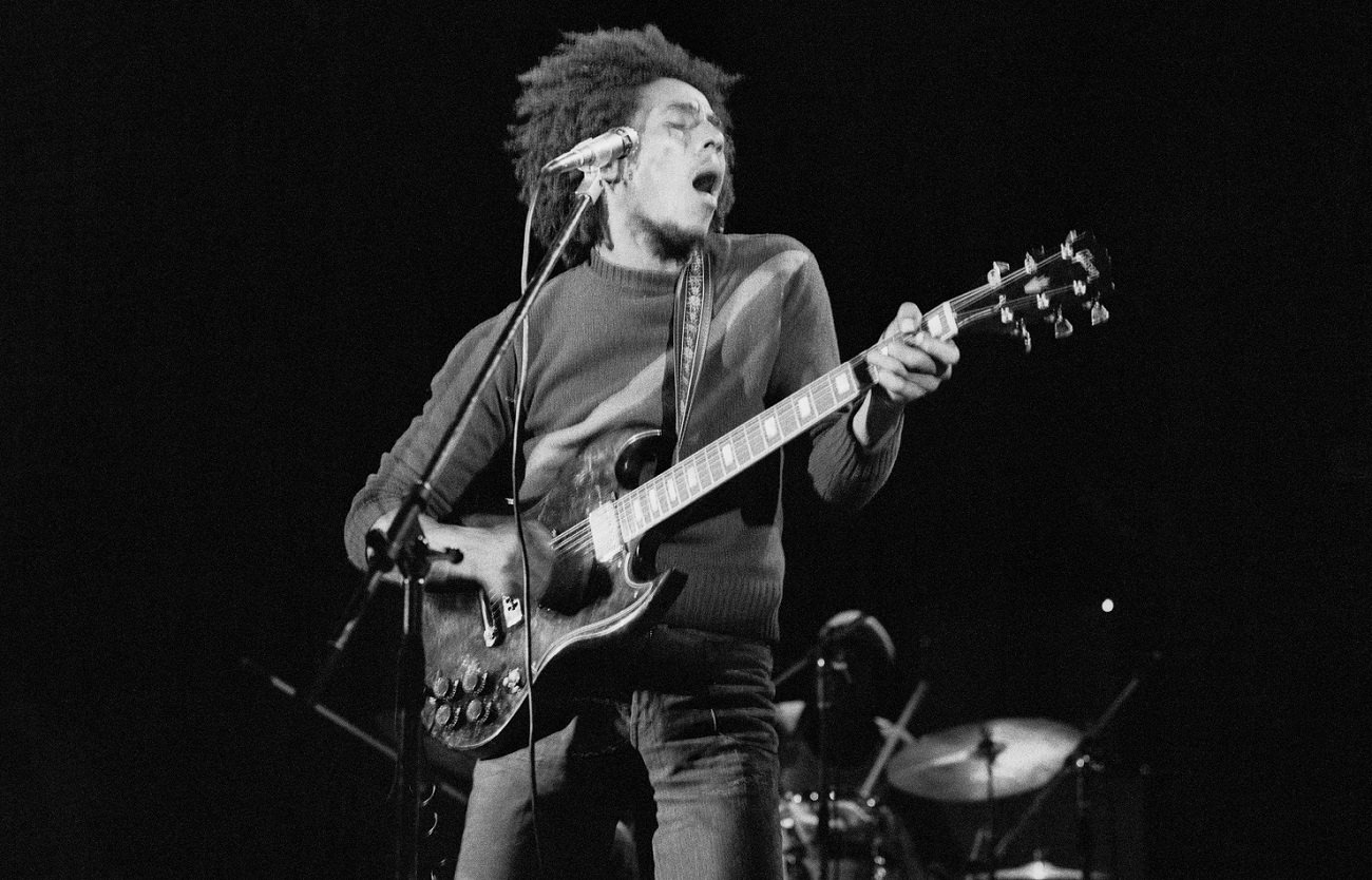 Bob Marley plays guitar with his eyes close on stage