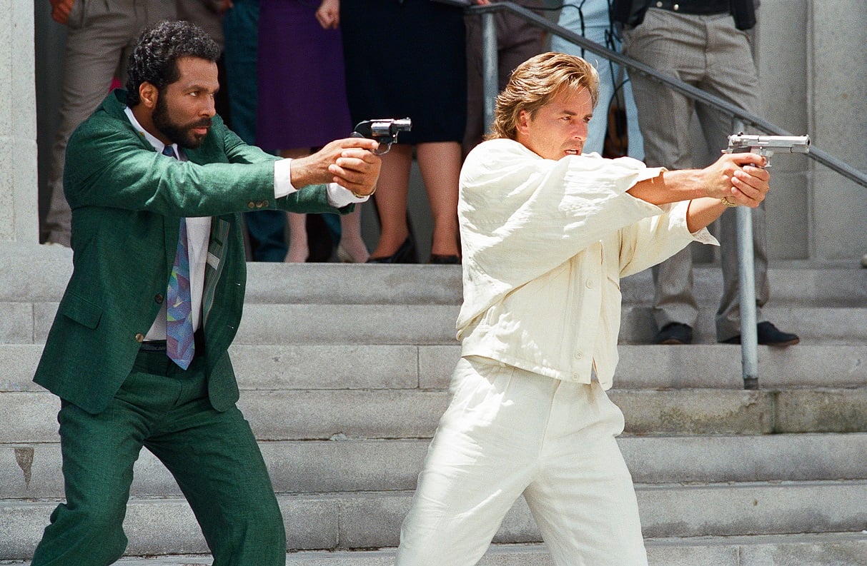 Philip Michael Thomas and Don Johnson point guns in character as vice detectives on the courthouse steps