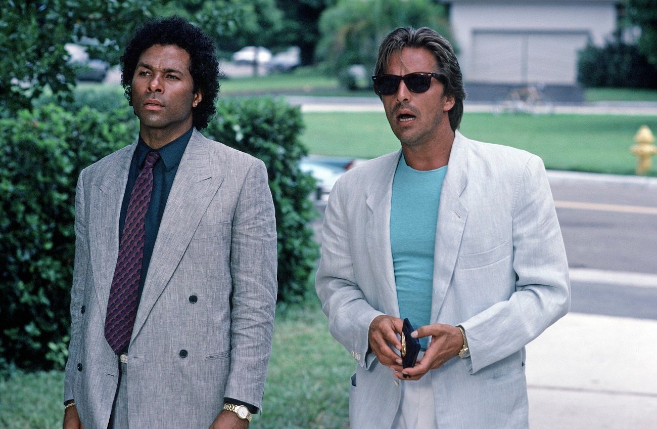 Don Johnson stands with his mouth agape in character as Sonny Crockett. Philip Michael Thomas stands to his right.