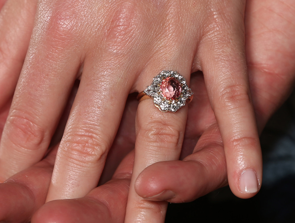 Princess Eugenie wears a ring containing a padparadscha sapphire surrounded by diamonds as she poses with Jack Brooksbank in the Picture Gallery at Buckingham Palace in London after they announced their engagement.