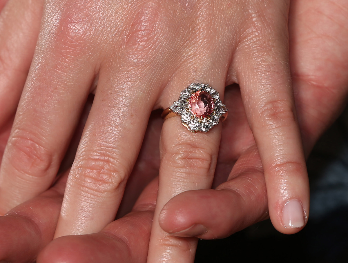 Princess Eugenie wears a ring containing a padparadscha sapphire surrounded by diamonds as she poses with Jack Brooksbank in the Picture Gallery at Buckingham Palace in London after they announced their engagement. 