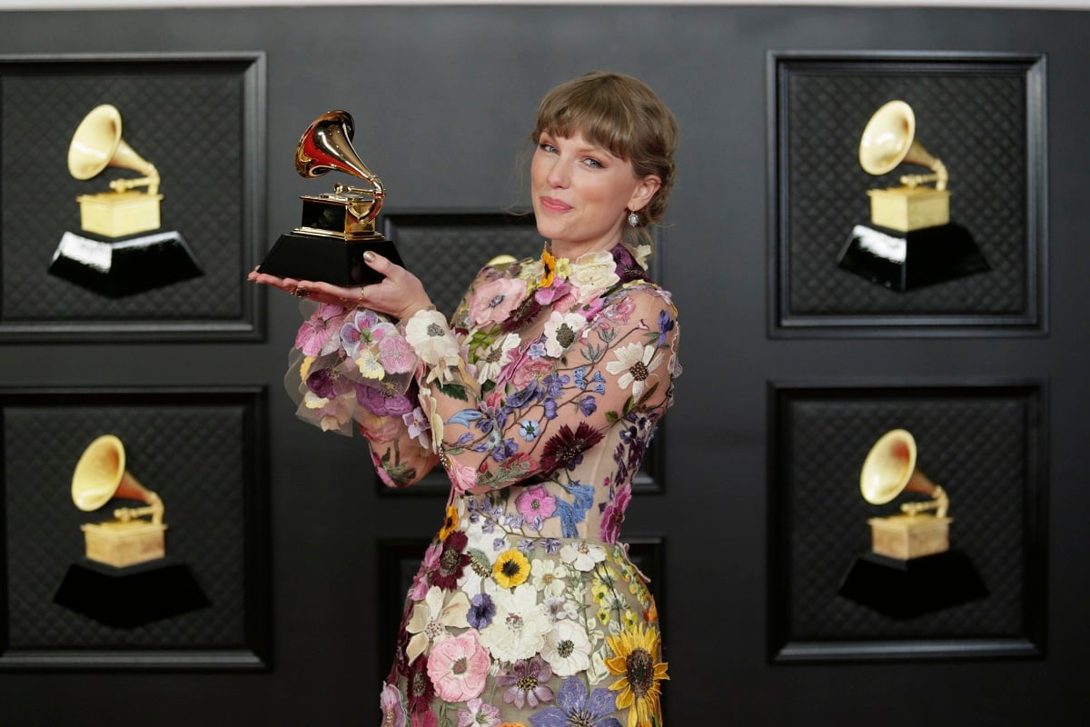 Taylor Swift holding her Grammy for Album of the Year in 2021. 