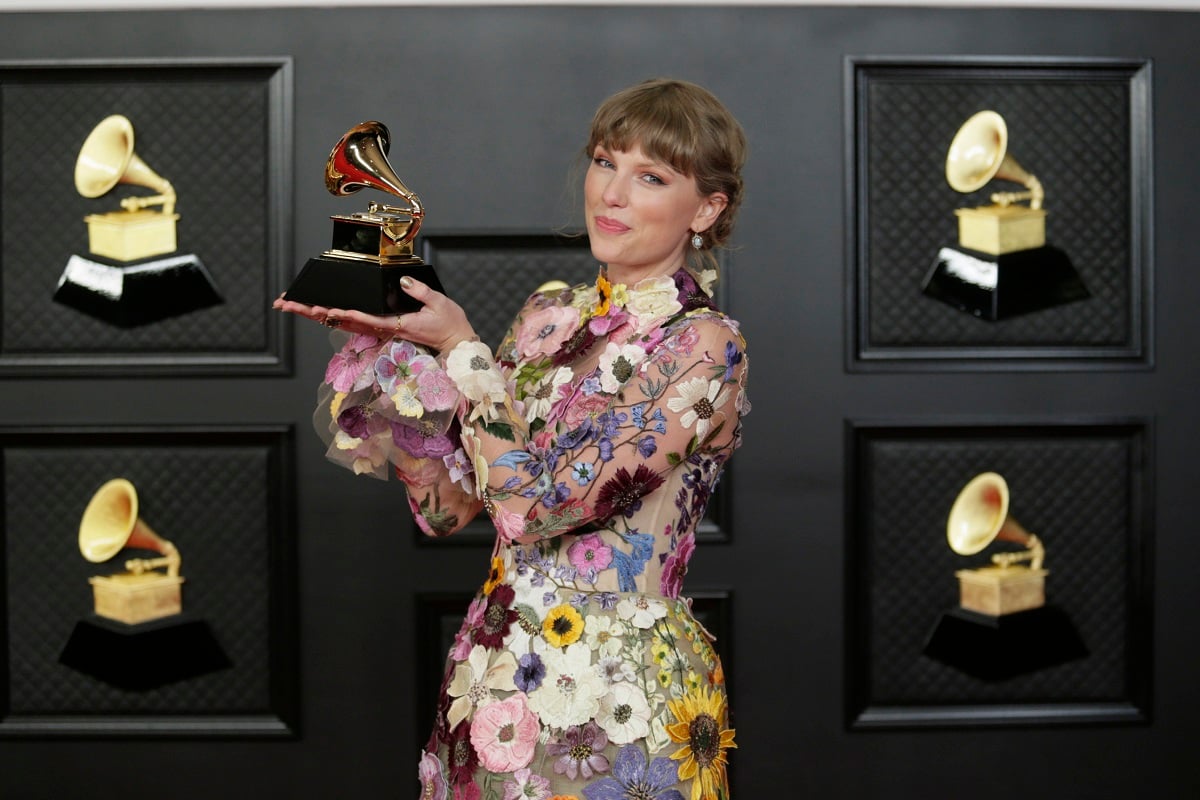Taylor Swift holding her Grammy for Album of the Year in 2021.