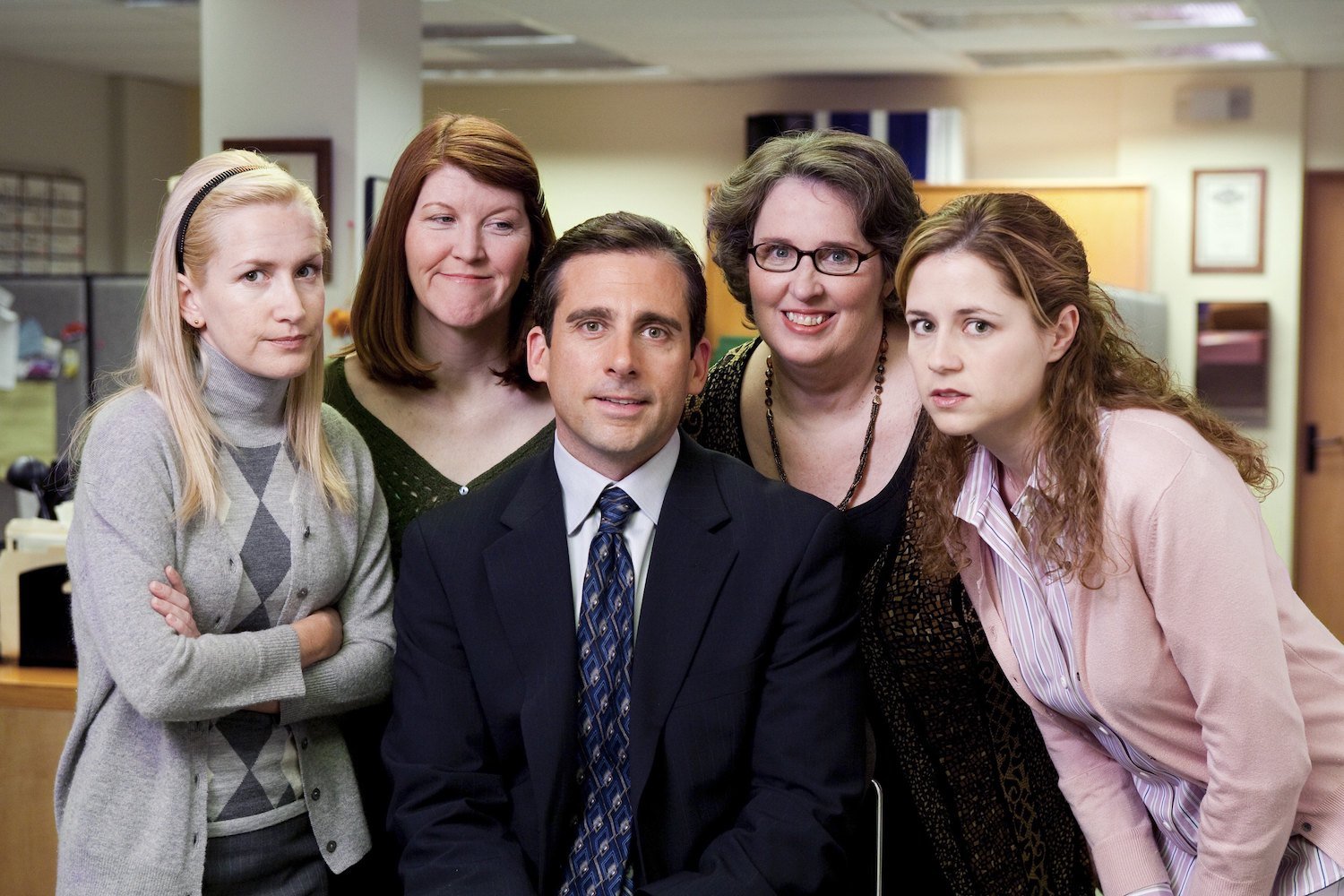 The Office cast in character: Angela Kinsey as Angela Martin, Kate Flannery as Meredith Palmer, Steve Carell as Michael Scott, Phyllis Smith as Phyllis Lapin, and Jenna Fischer as Pam Beesly 